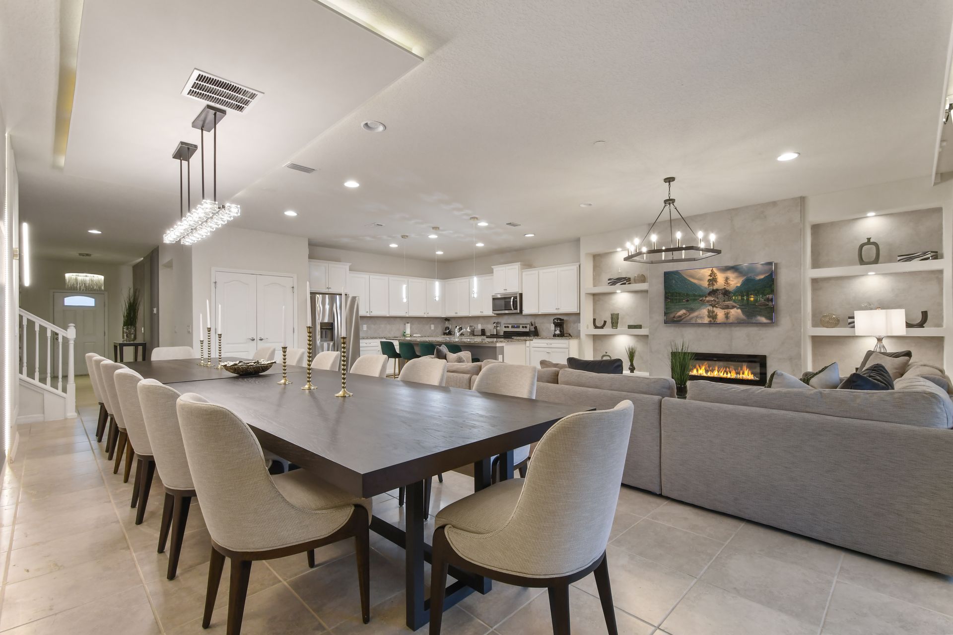 Spacious open-concept dining and living area with modern kitchen and fireplace.