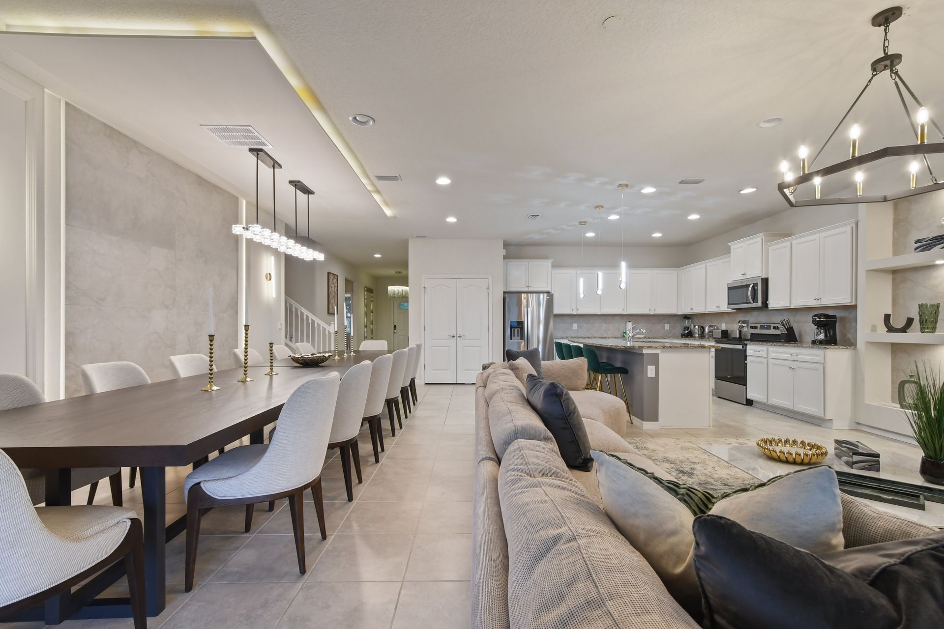 Open-concept living space featuring a long dining table, cozy seating, and modern kitchen.