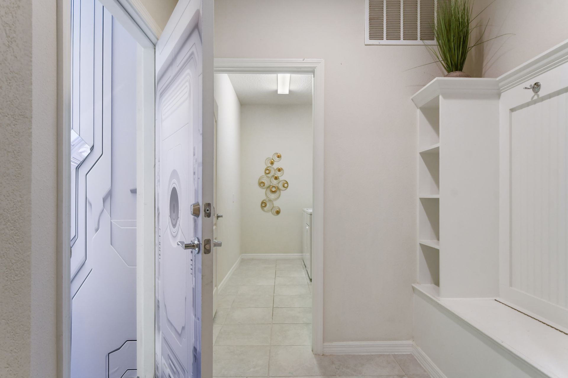 Modern mudroom with storage, leading to a sleek laundry area.