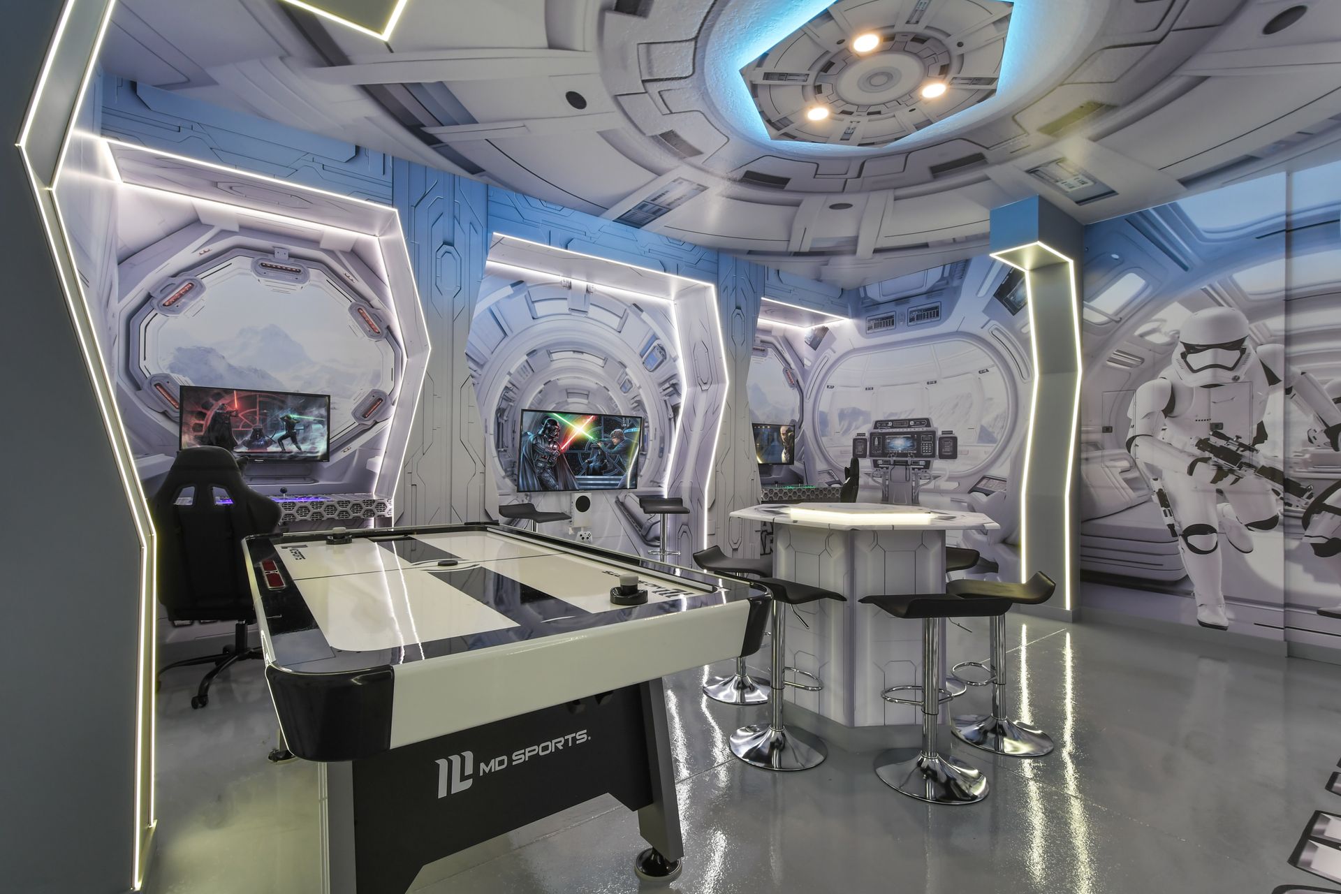 Futuristic Star Wars-themed game room with air hockey, gaming setups, and décor.
