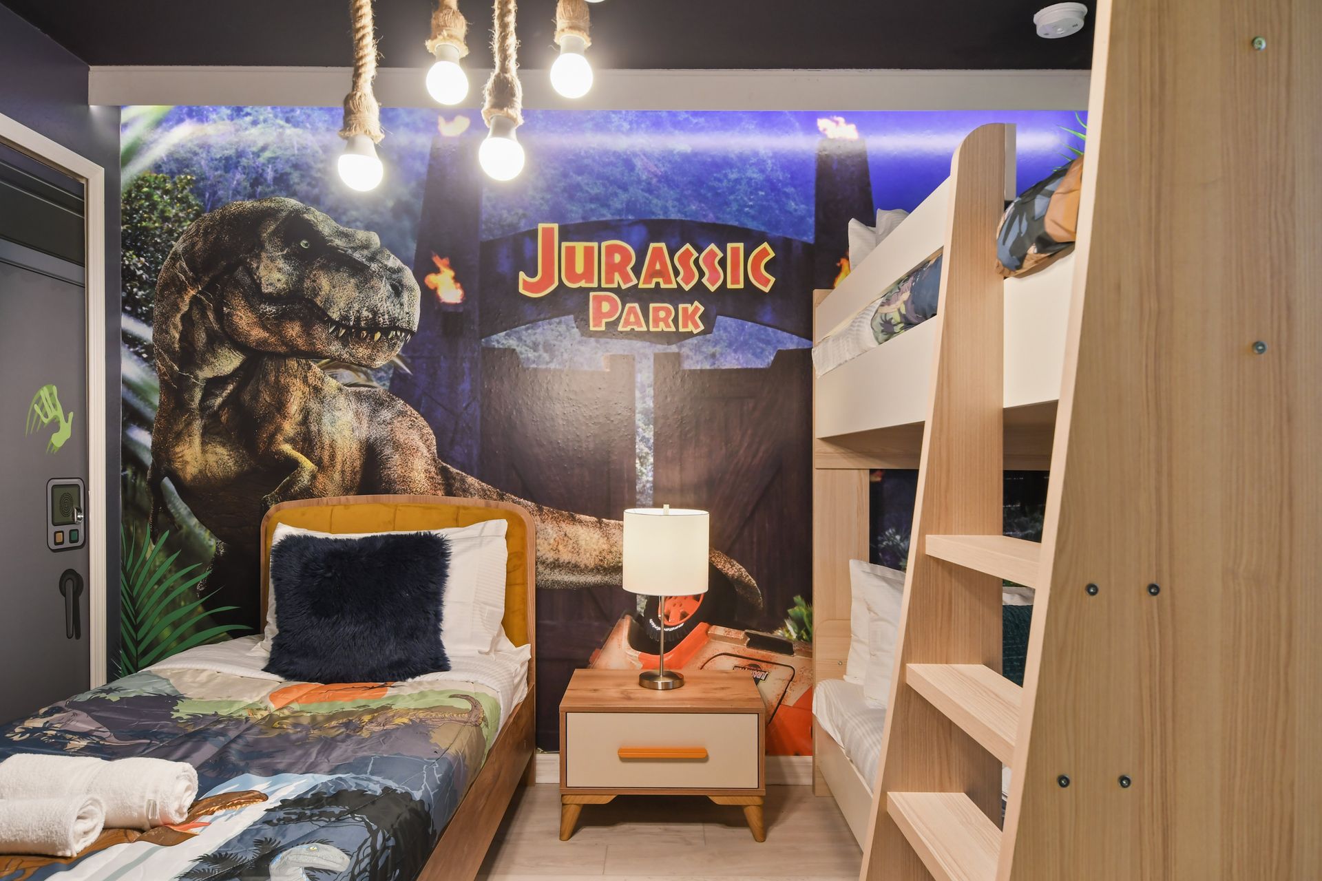 Step into a Jurassic adventure! Dino-themed room with cozy beds & jungle vibes!