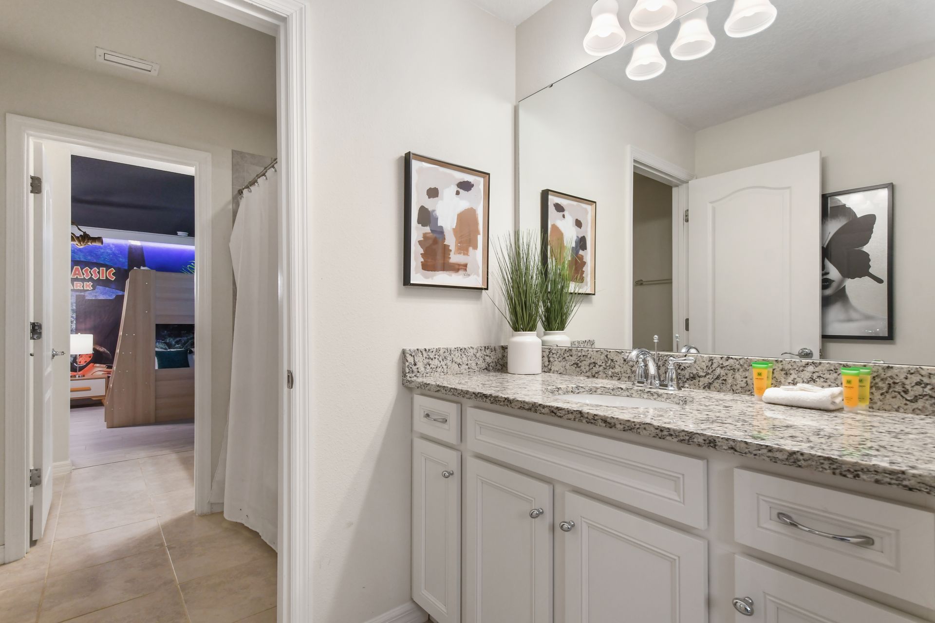 Elegant bathroom with dual sinks, granite counters, walk-in shower & pool access!