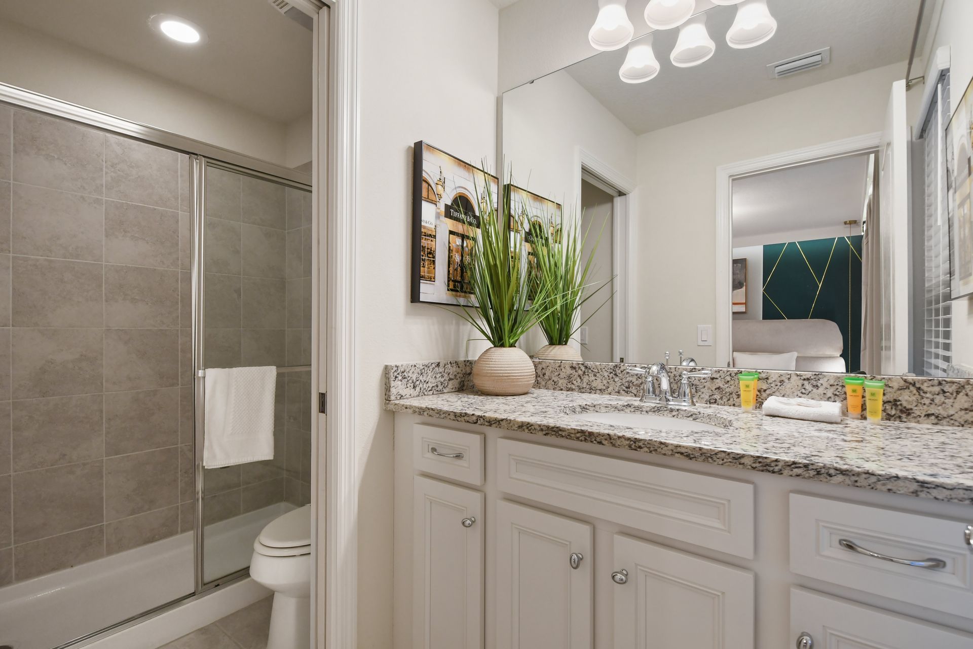 Modern bathroom with dual sinks, granite countertops & a sleek glass walk-in shower!