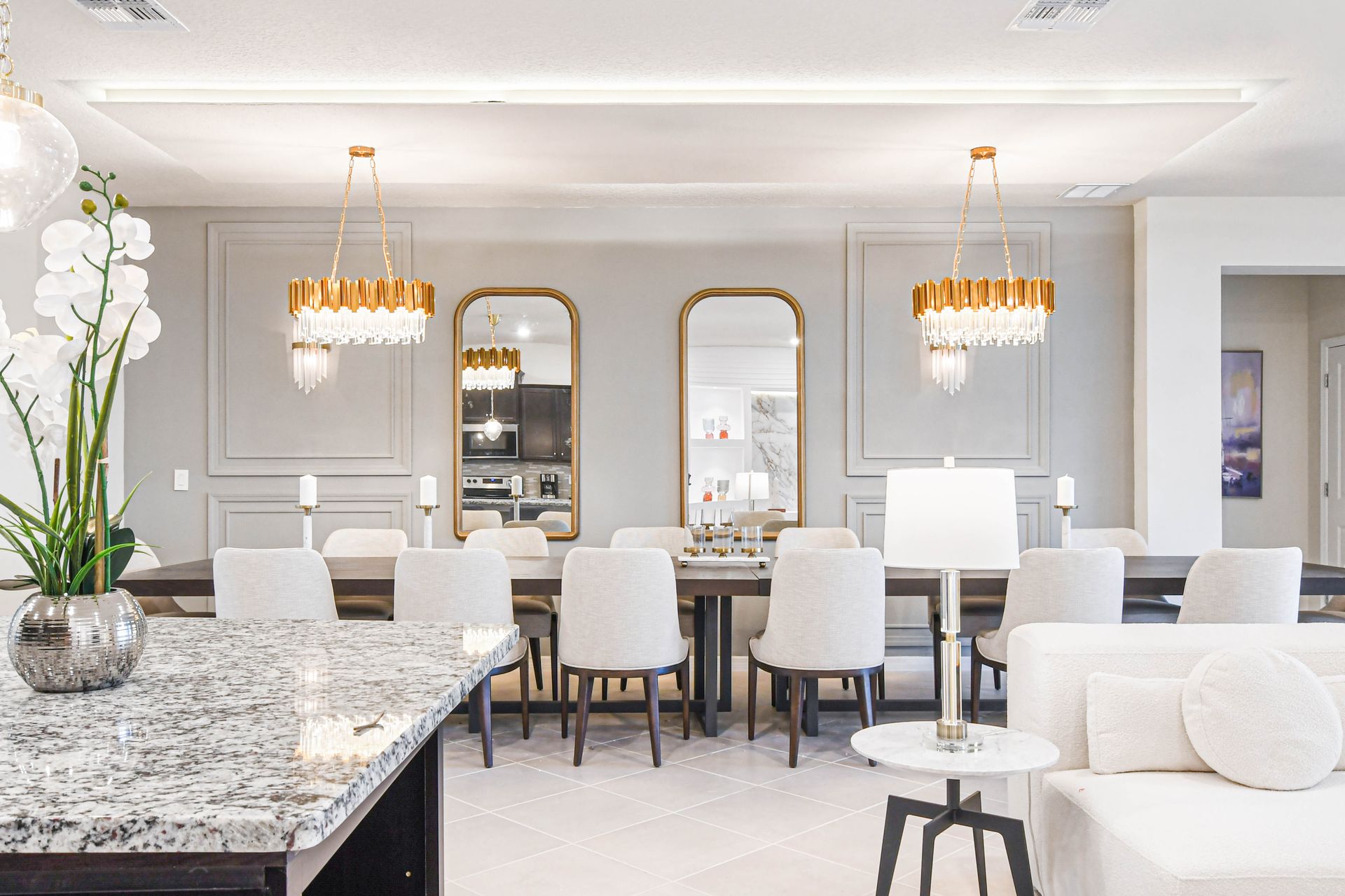 Elegant dining space with statement chandeliers, gold accents, and modern décor