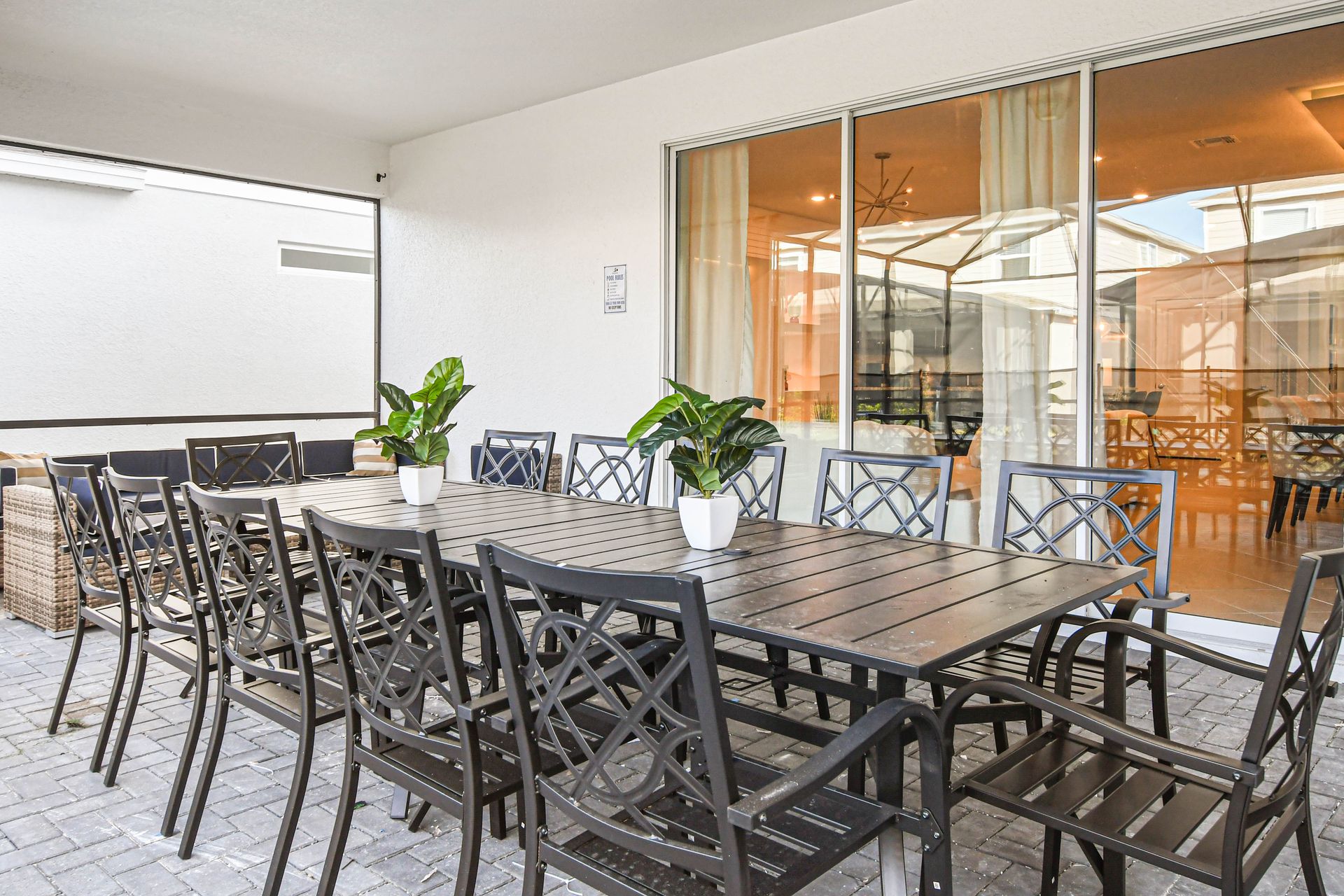 Outdoor dining for twelve with covered seating, cozy lounge area, and pool views