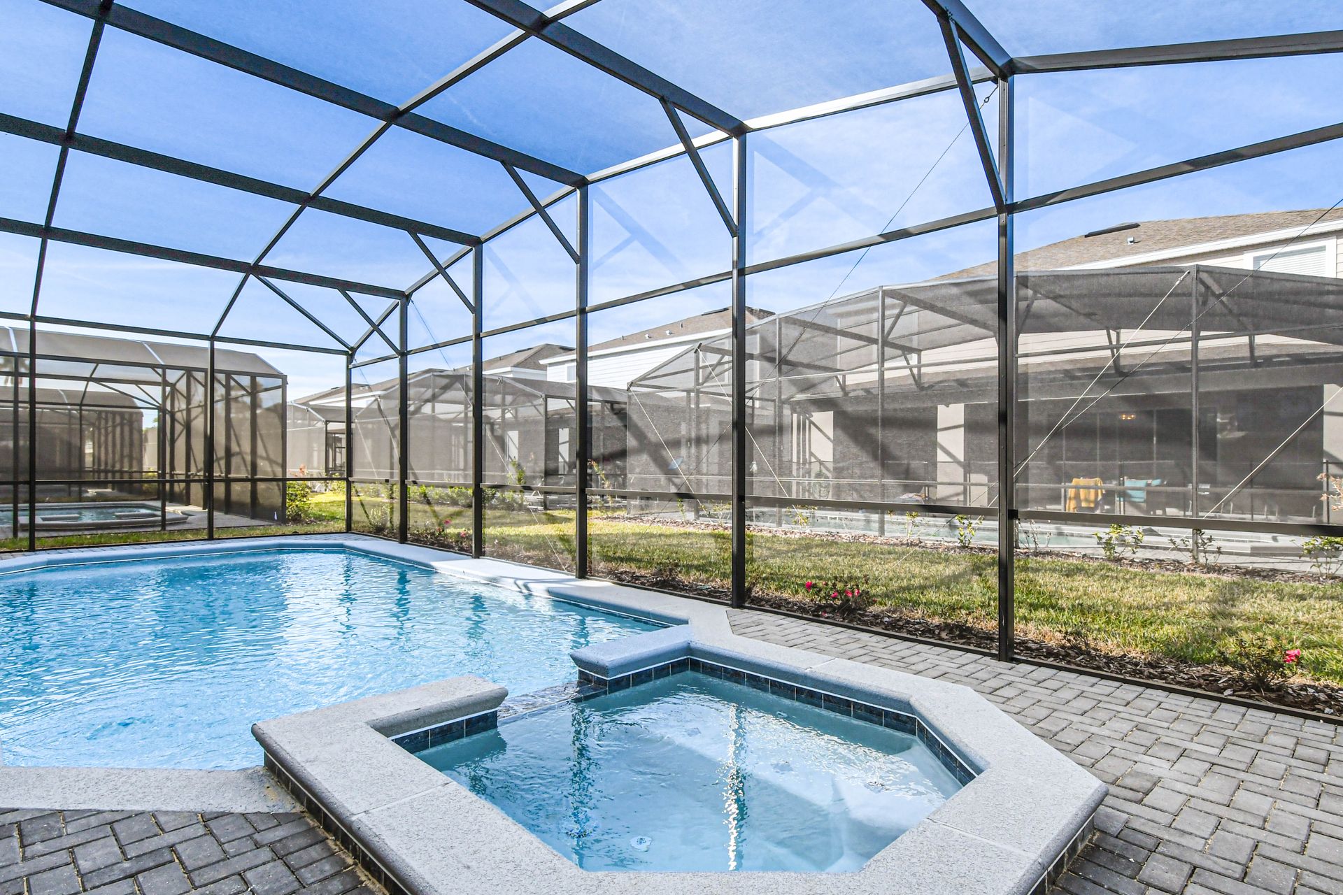 Spacious screened lanai with pool, spa, dining area, and relaxing outdoor lounge