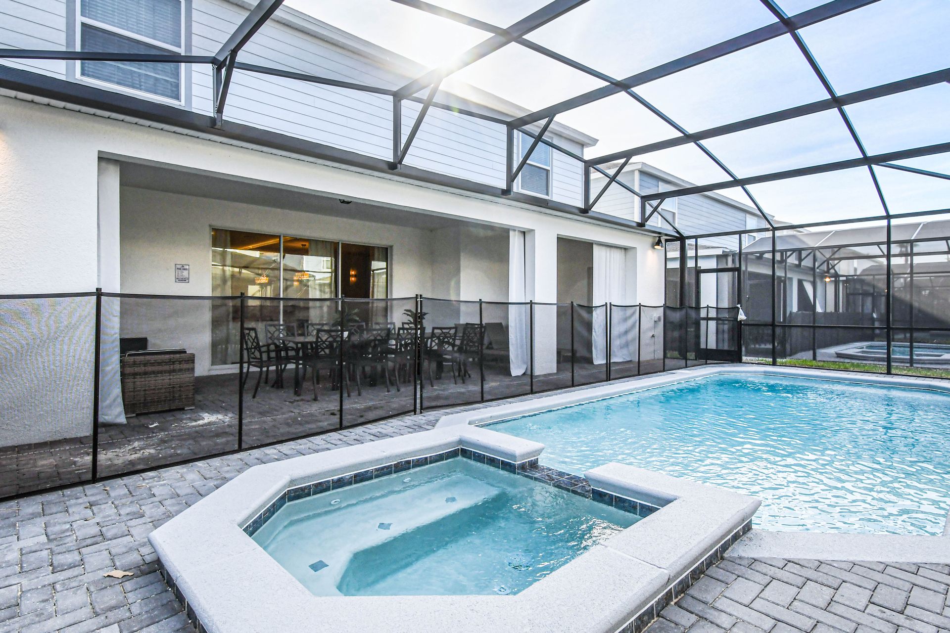 Spacious screened lanai with pool, spa, dining area, and relaxing outdoor lounge