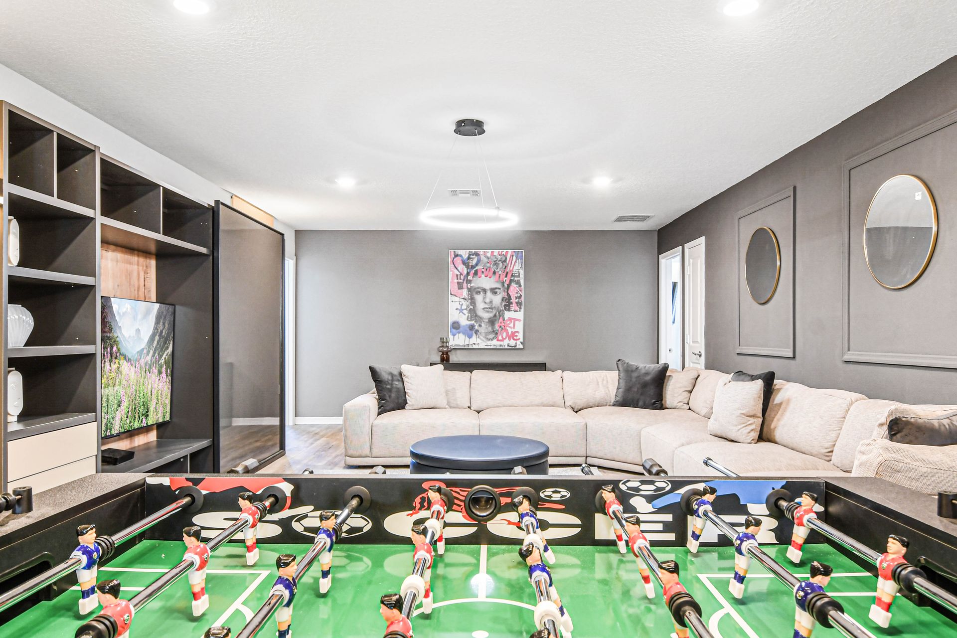 Stylish game room with foosball, large sectional, and modern entertainment setup