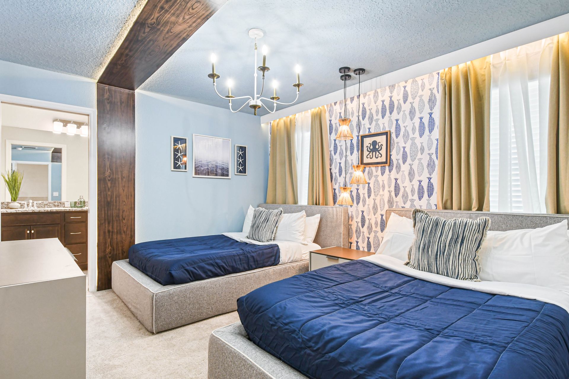 Coastal-inspired room with double beds, bold patterns, and modern nautical charm