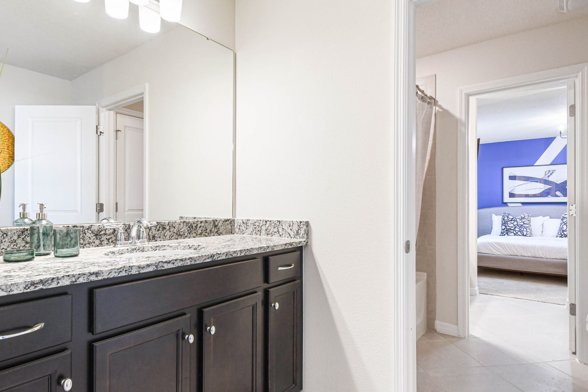 Elegant shared bath with granite vanity, tub-shower combo, and access to king suite