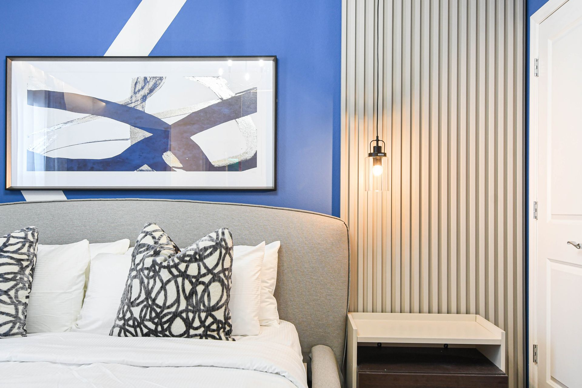 Bold and modern king bedroom with abstract art, accent wall, and cozy vibes