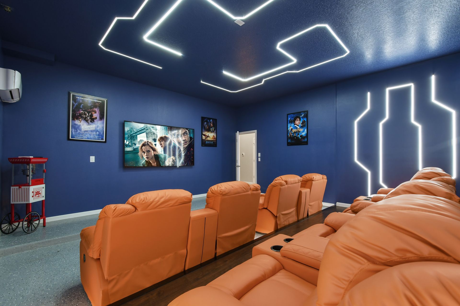 Futuristic home theater with plush recliners, neon lighting, and an immersive ambiance.