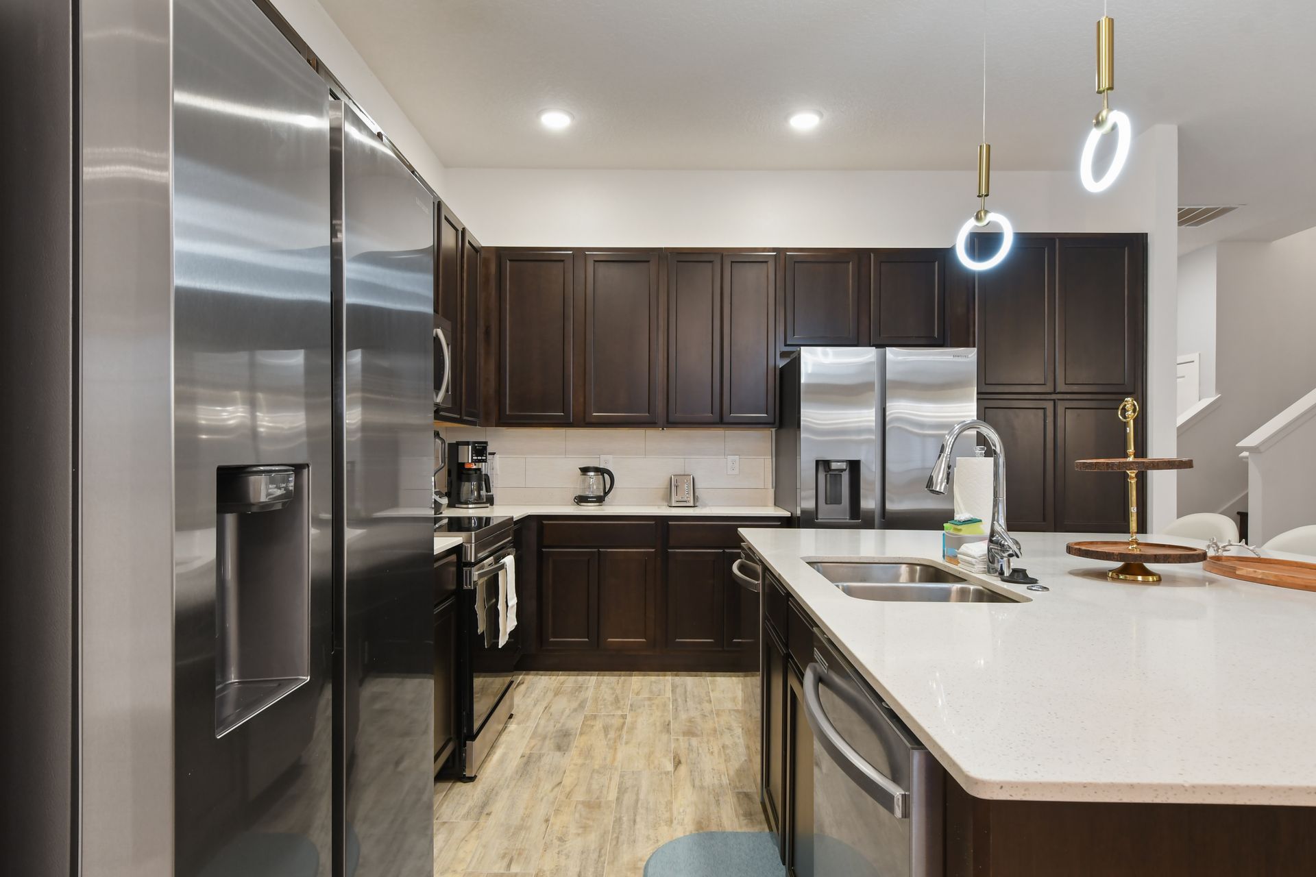 Stylish modern kitchen with dark cabinetry, stainless steel appliances, and a spacious island.
