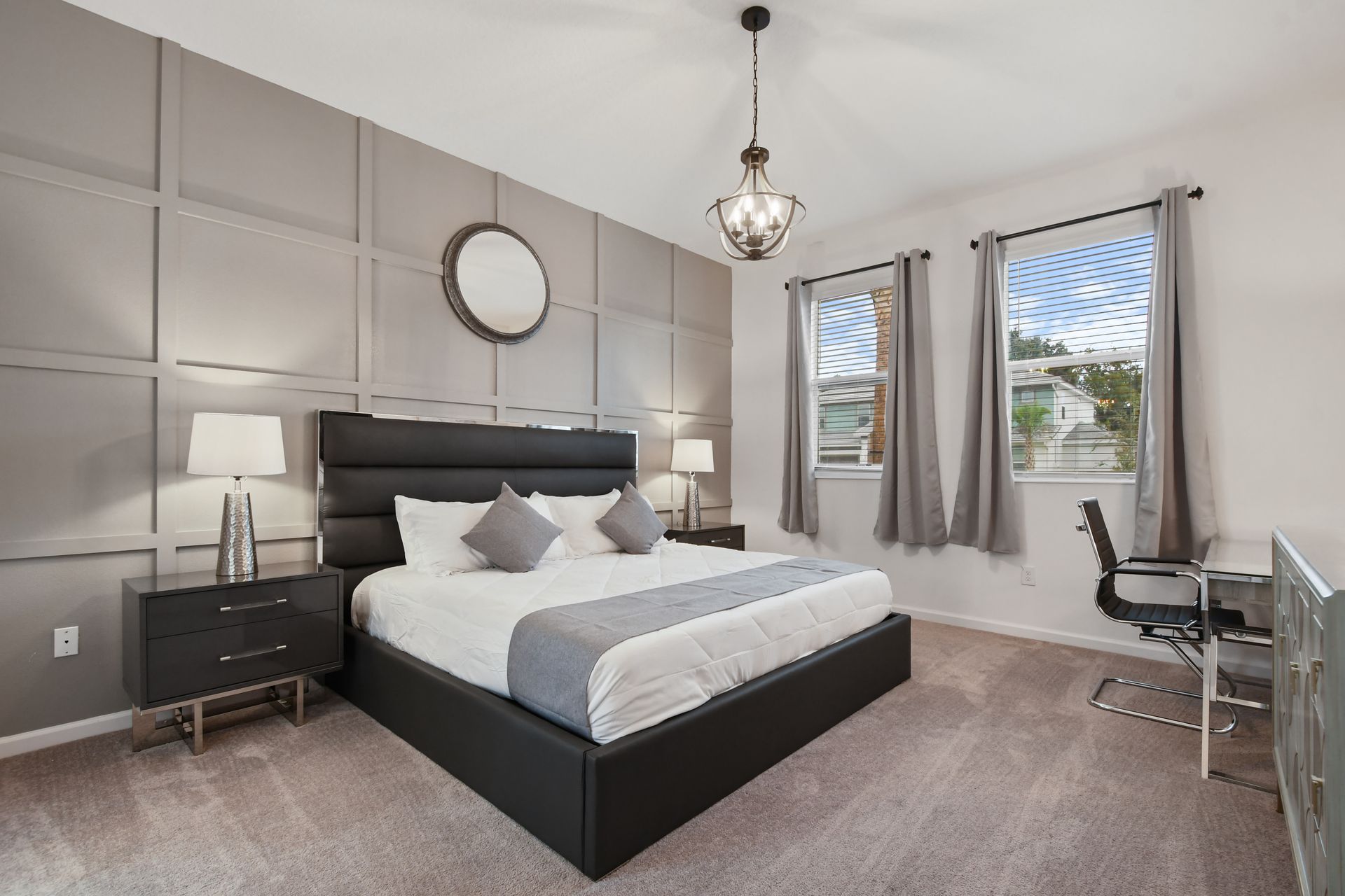 Sophisticated master bedroom with modern decor, plush bedding, and a stylish workspace.