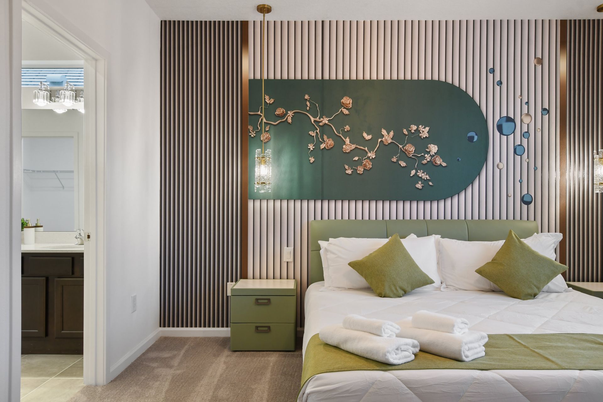 Elegant master bedroom with nature-inspired decor, a chandelier, and a cozy crib.