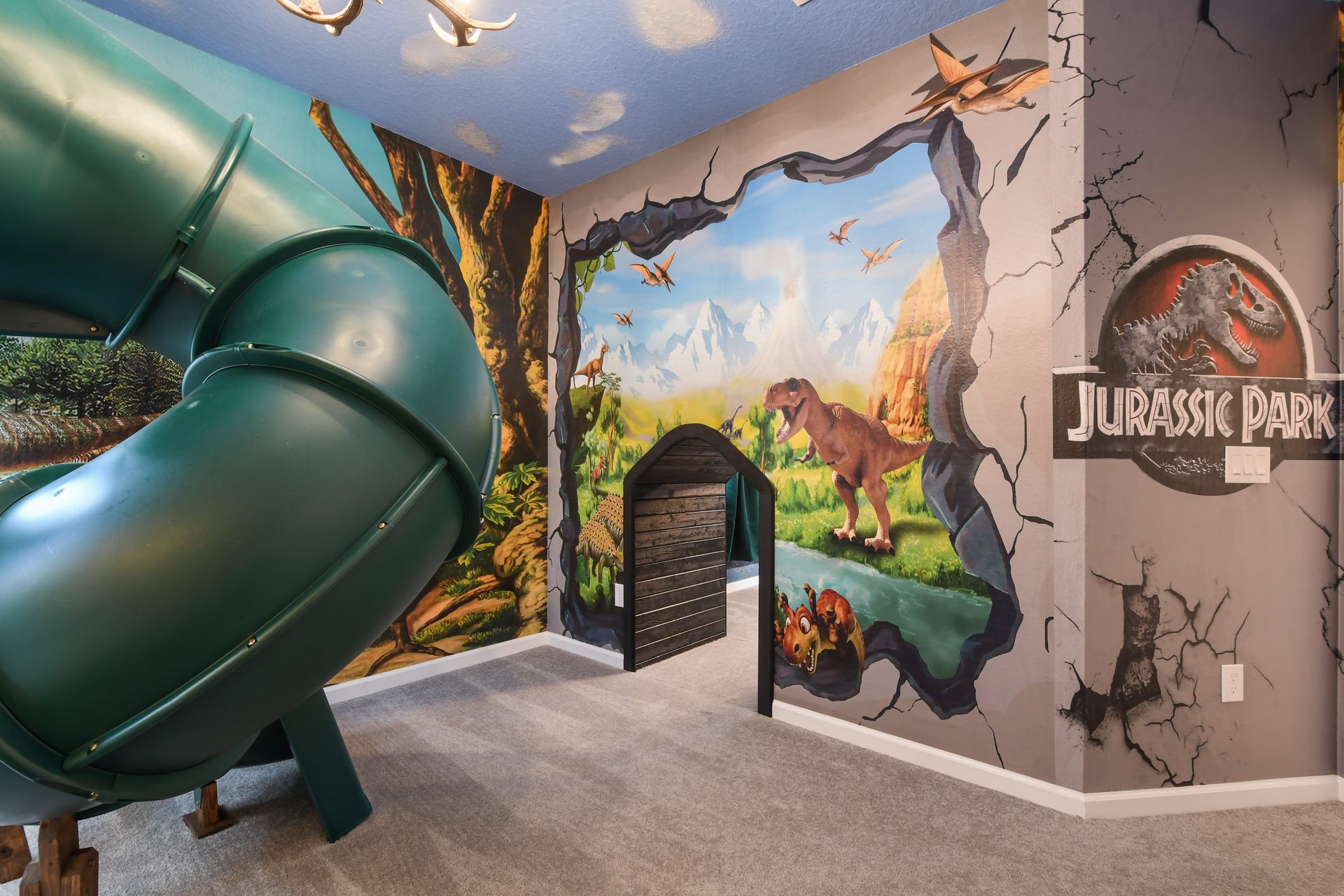 Epic dinosaur-themed bedroom with jungle murals, a bunk bed, and an indoor slide.