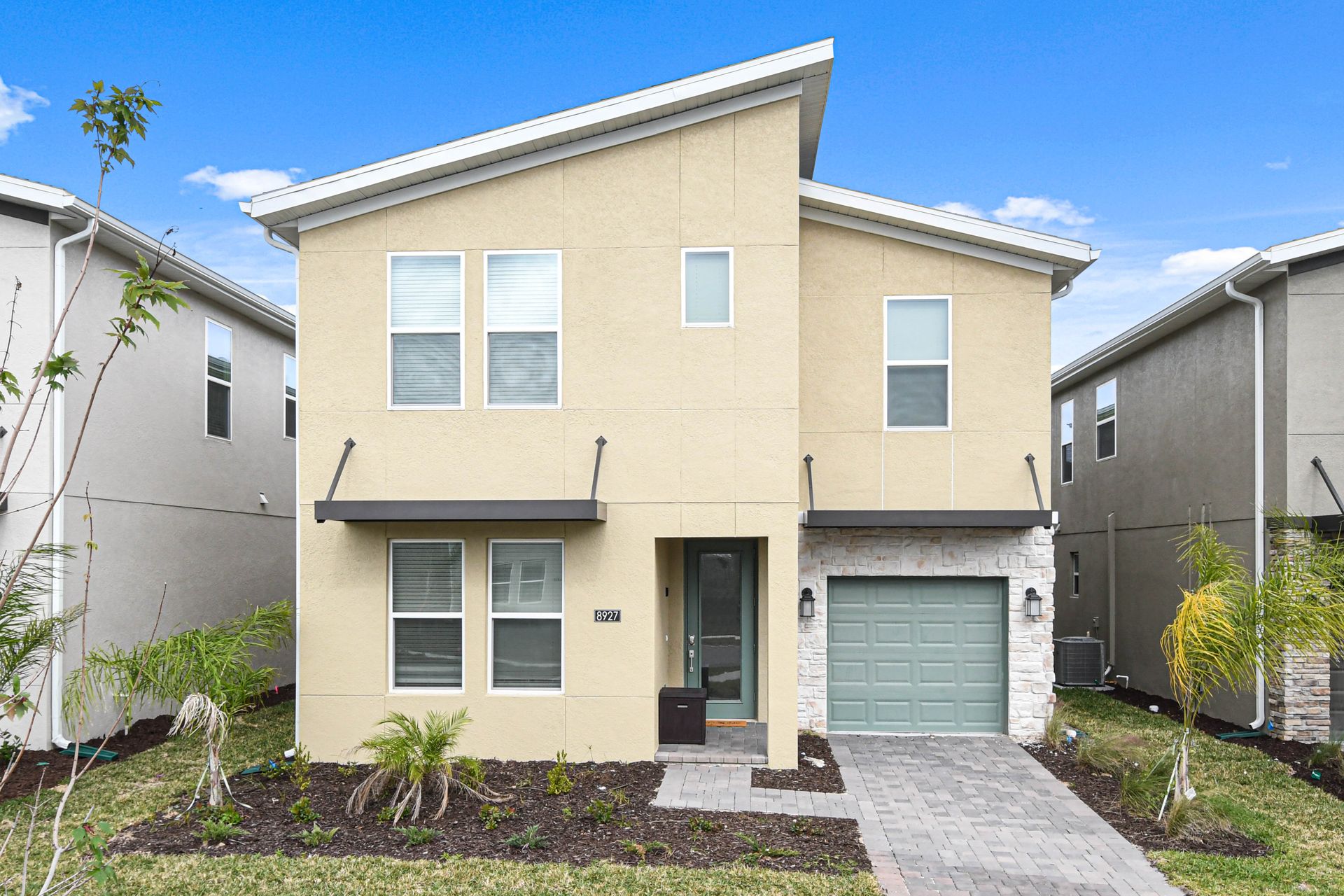 Modern family vacation home with sleek design, private garage, and sunny curb appeal.
