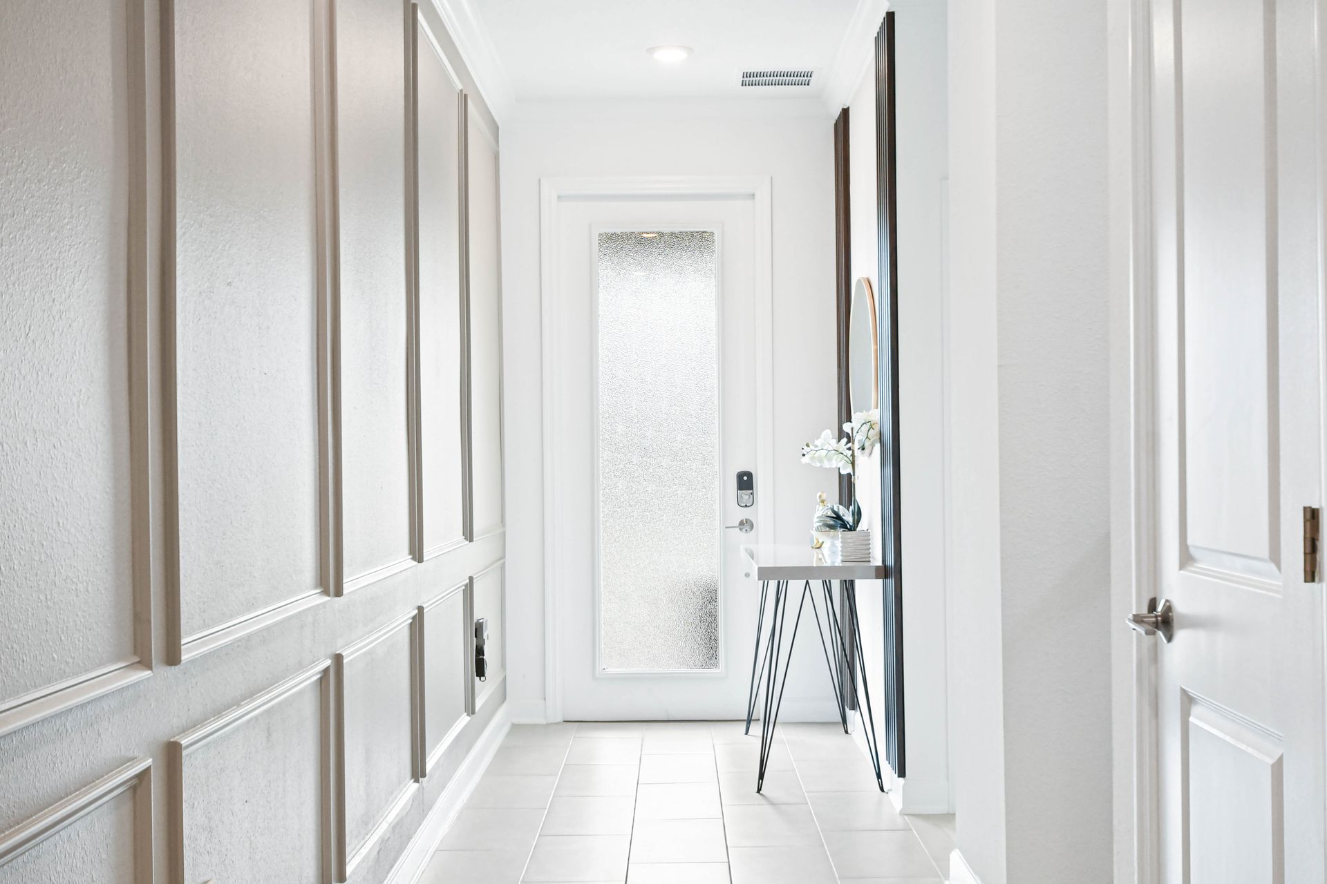 Bright, modern entryway with elegant paneling, sleek décor, and welcoming natural light.