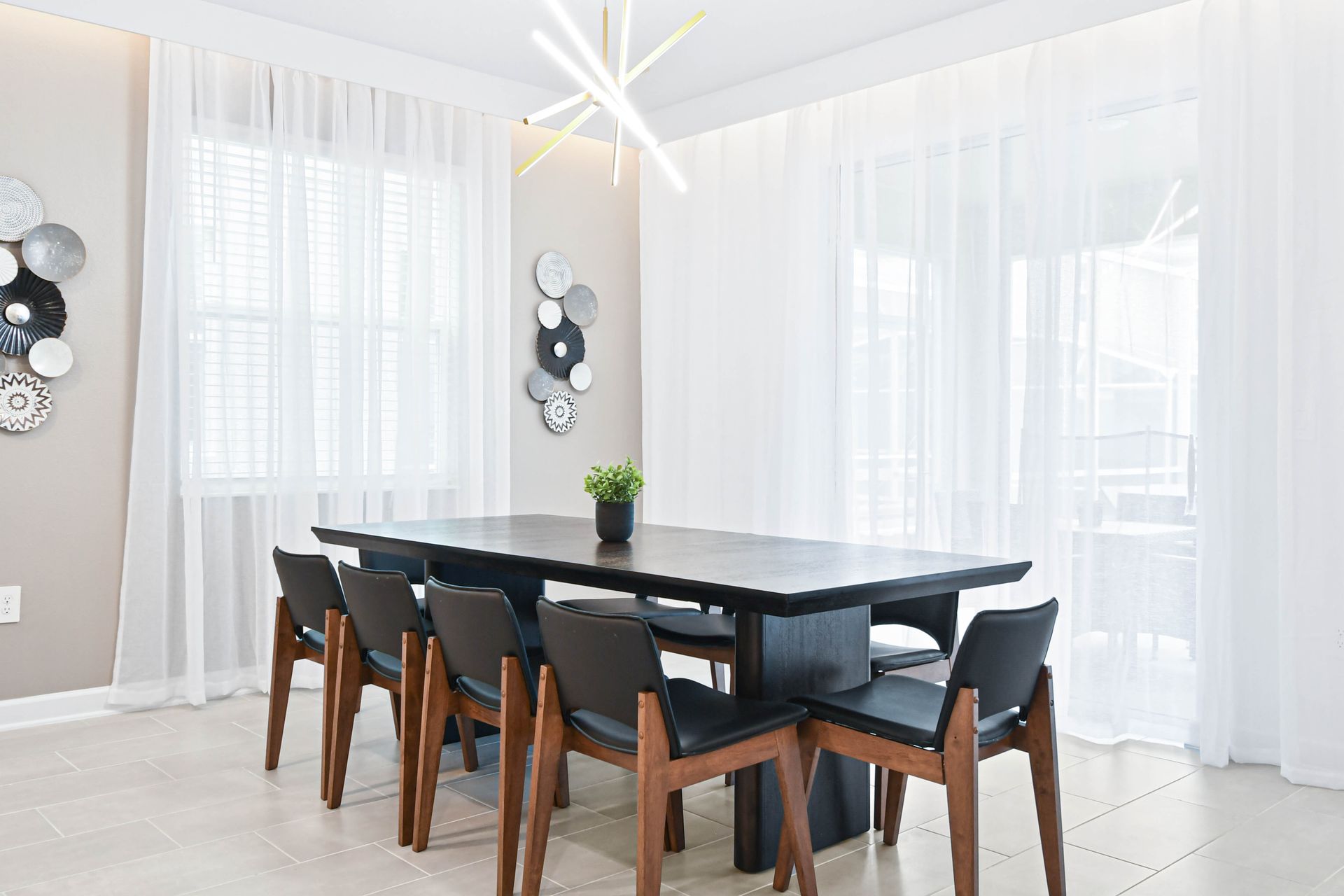Stylish dining area with modern lighting, seating for eight, and bright airy vibes.
