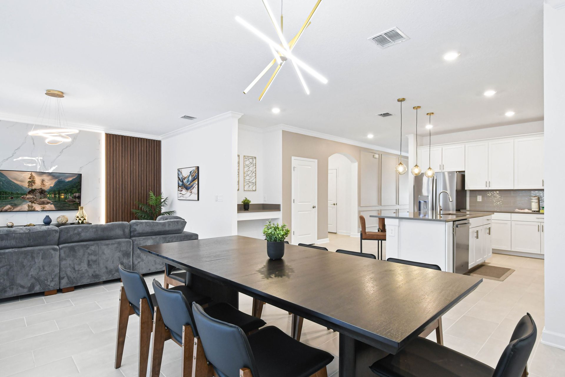 Spacious open-plan dining and kitchen area with modern lighting and elegant style.