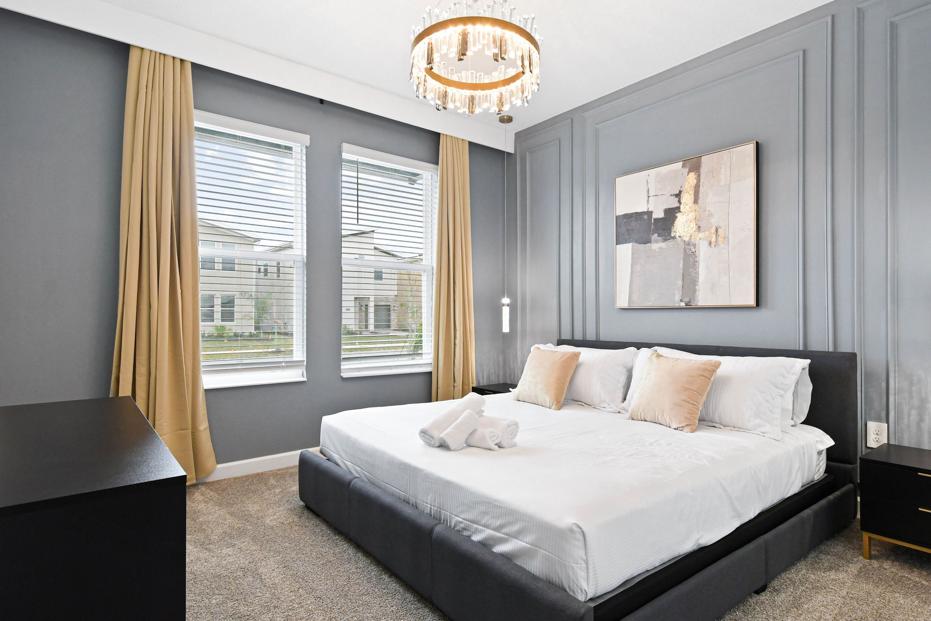 Sophisticated bedroom with chic gray tones, plush king bed, and crystal chandelier.