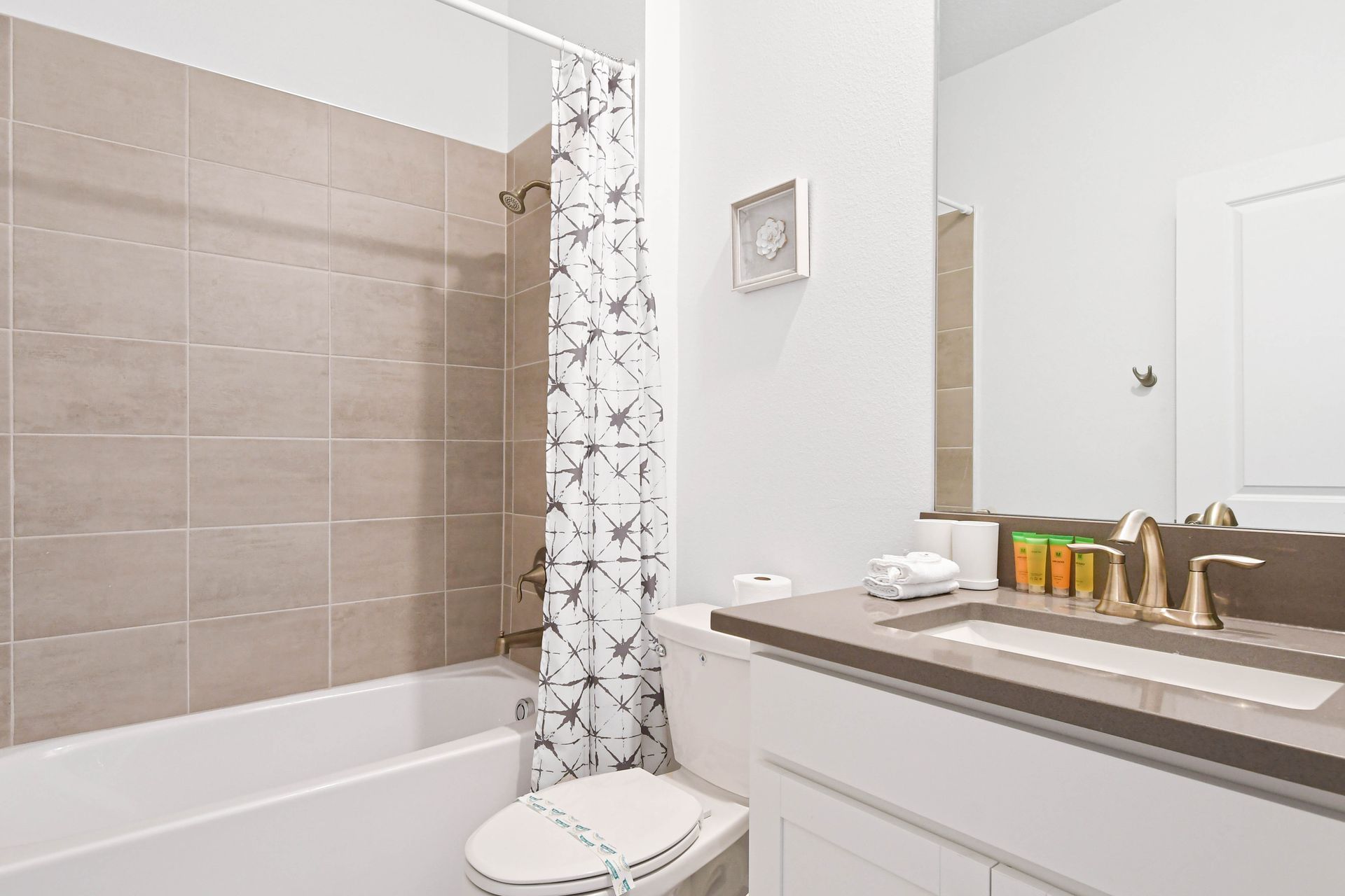 Modern bathroom with sleek fixtures, spacious vanity, fresh towels, and a clean design.
