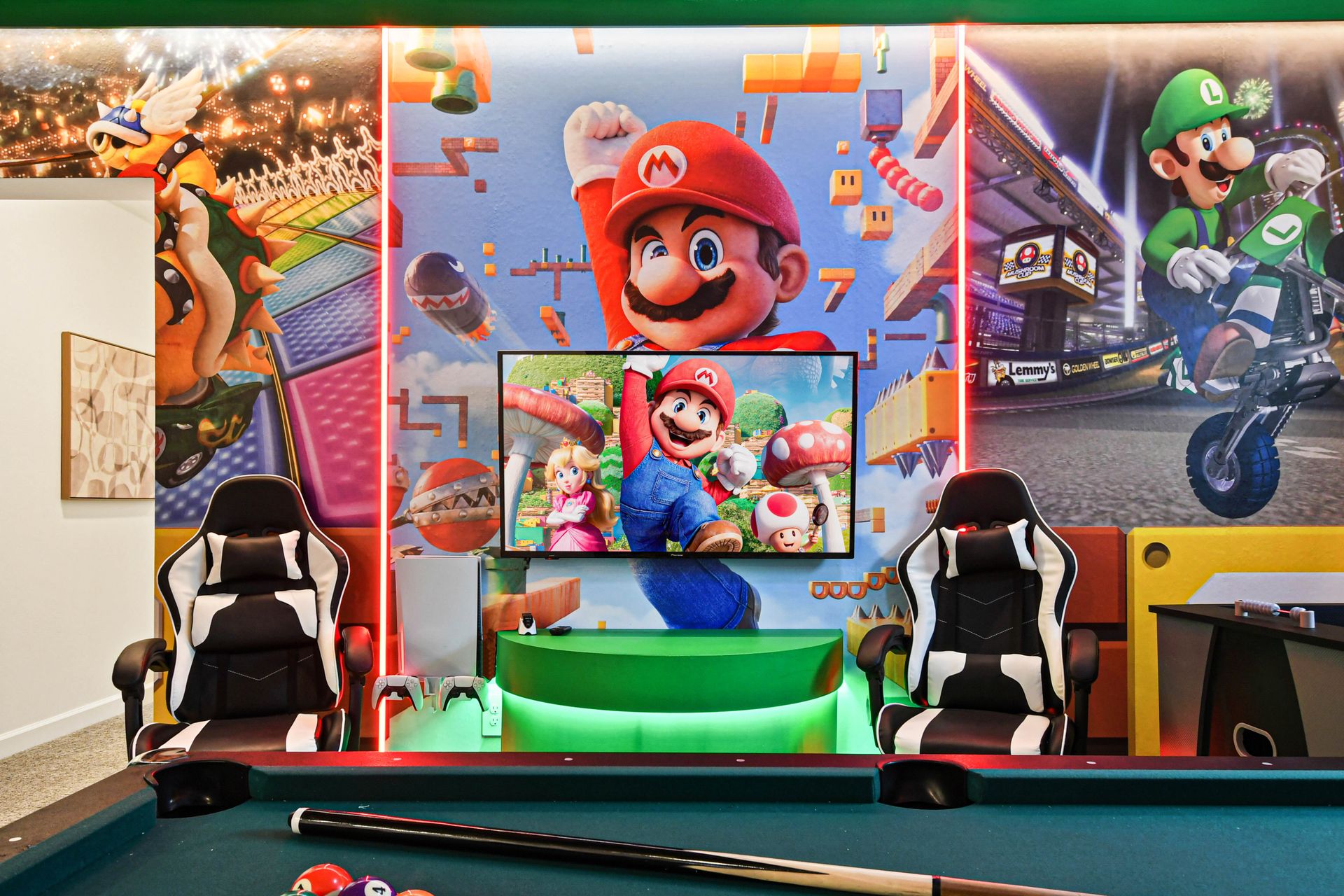 Colorful Mario-themed game room with pool, foosball, gaming setup, and playful murals.