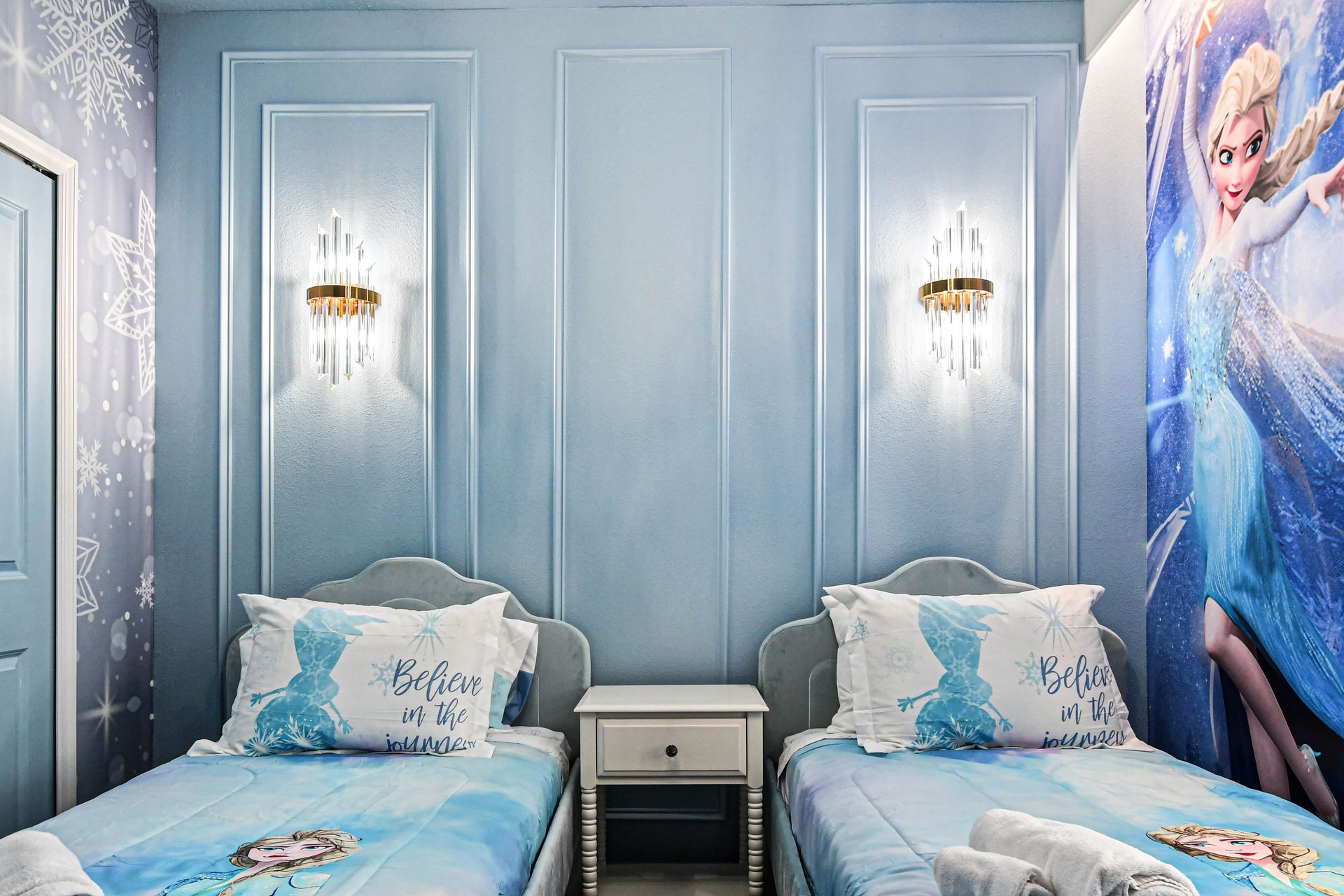 Charming Frozen-themed kids’ room with twin beds, shimmering walls, and icy magic.