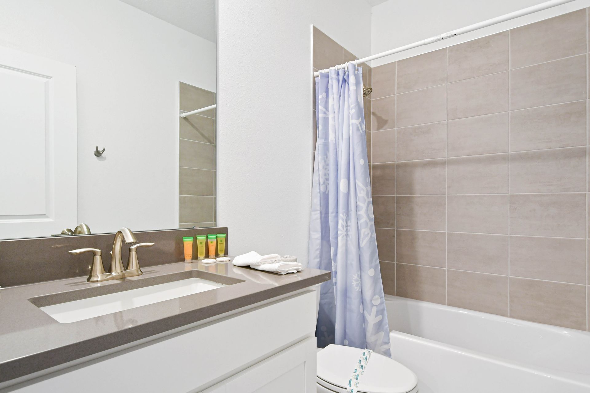 Bright, clean bathroom with modern vanity, sleek fixtures, and fresh shower amenities.
