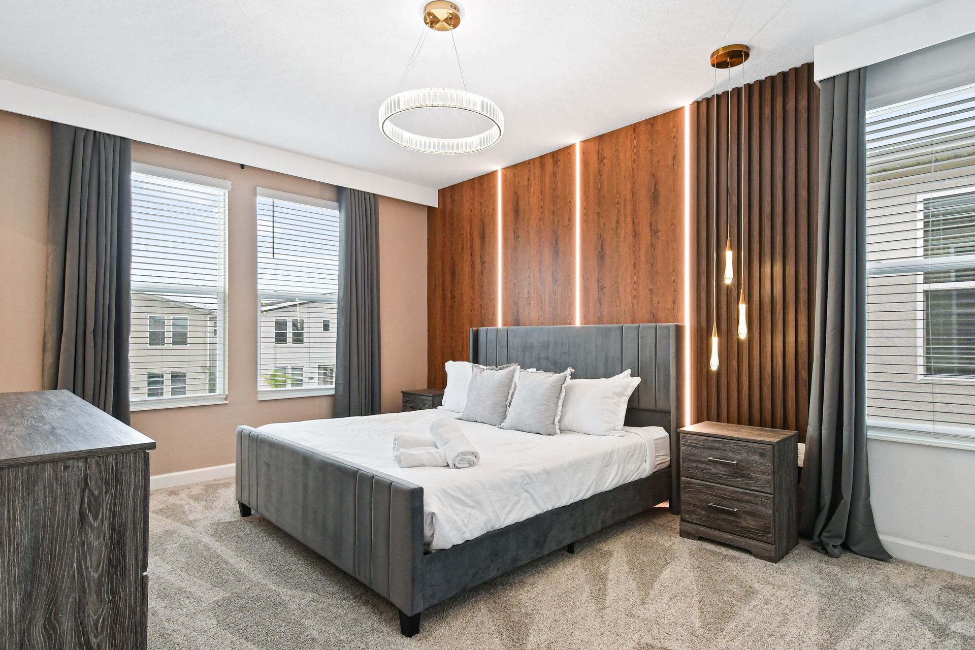 Elegant bedroom retreat with plush king bed, modern lighting, and warm wood details.
