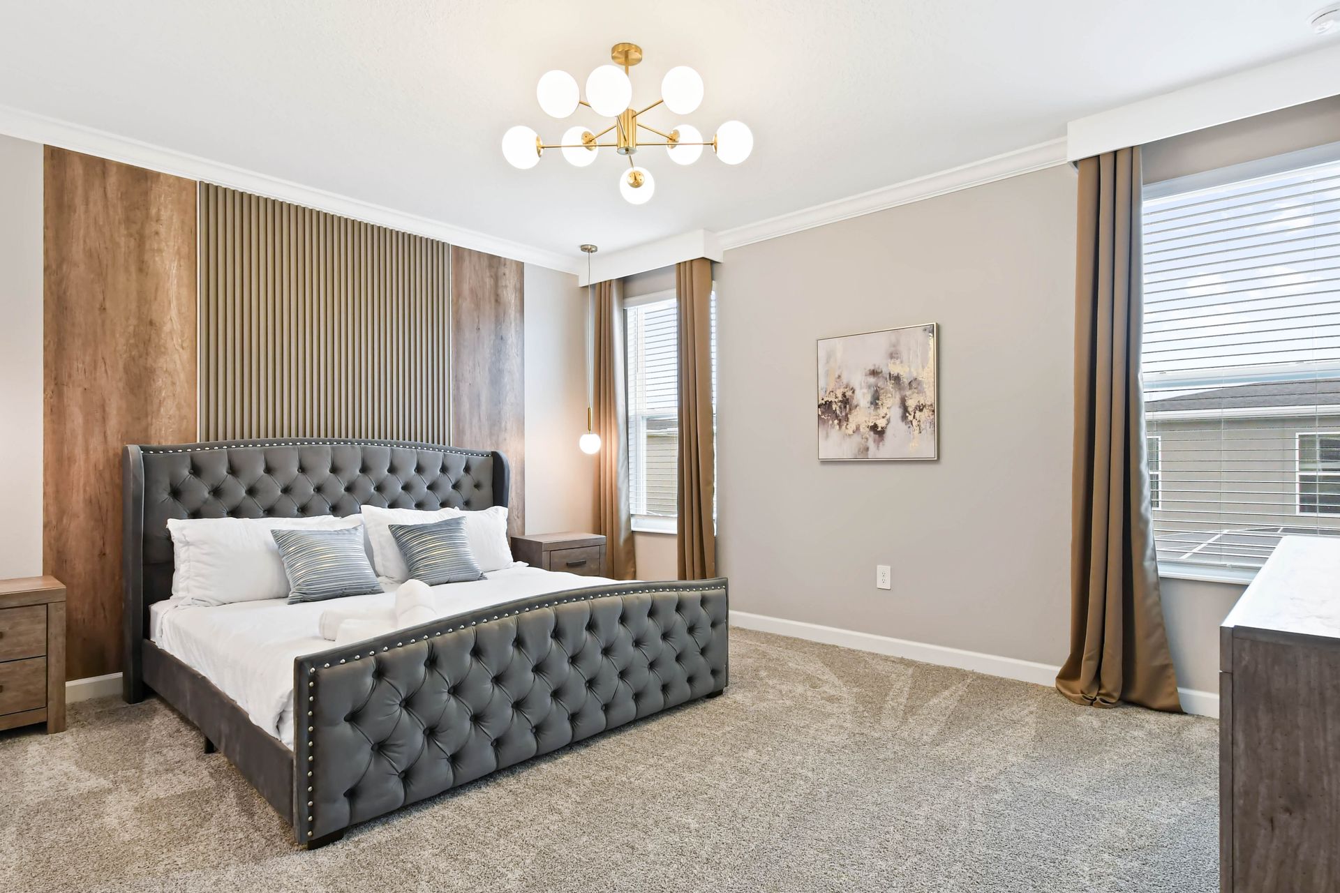 Luxurious bedroom with tufted bed, elegant lighting, warm tones, and modern charm.