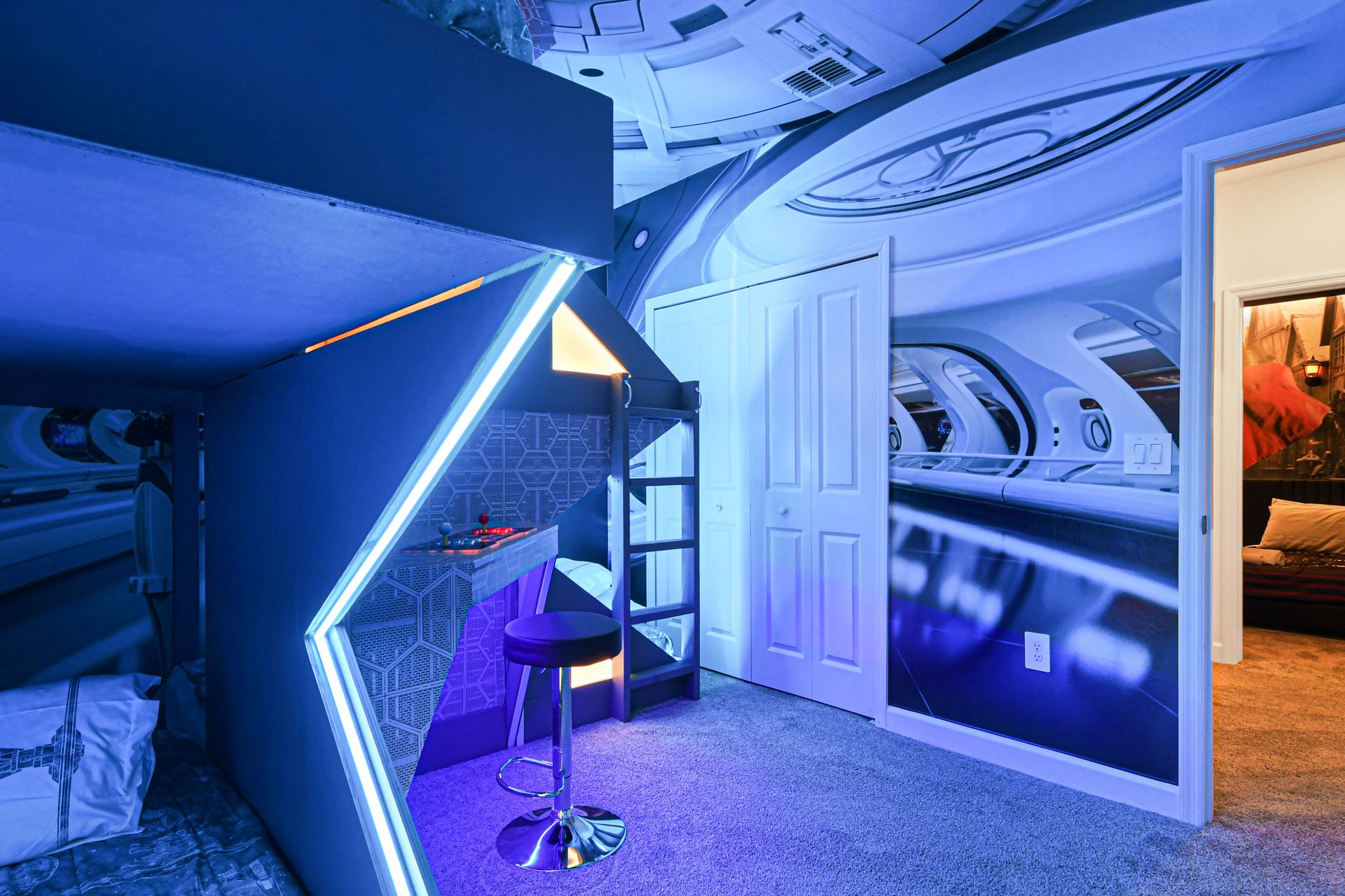 Futuristic space bunk room with glowing arcade setup, galactic walls, and cool vibes.