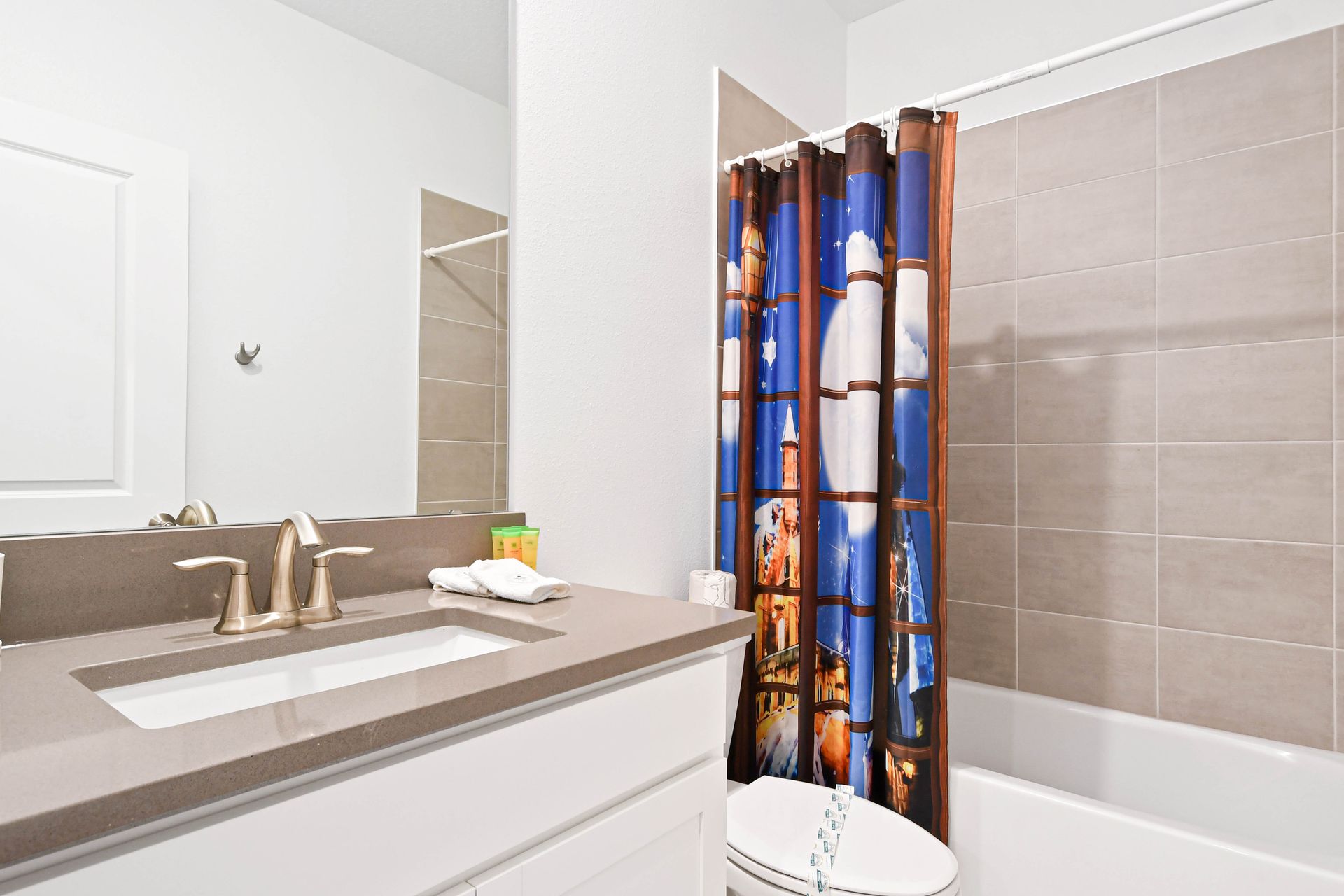 Charming bathroom with playful shower curtain, modern vanity, and fresh essentials.