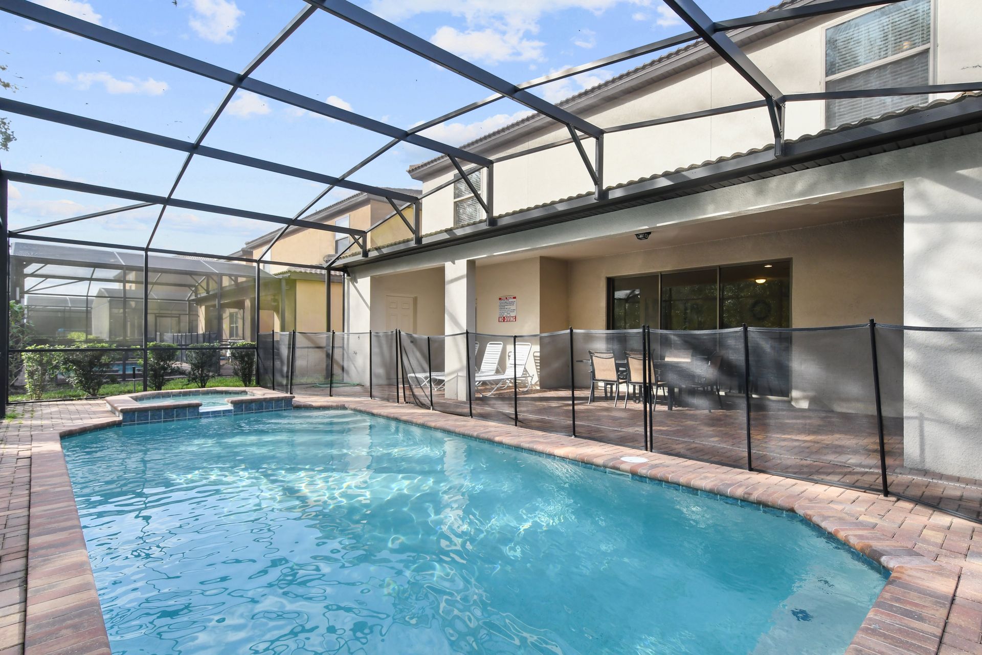 Spacious screened patio with pool, spa, dining area, and sunny private retreat vibes.