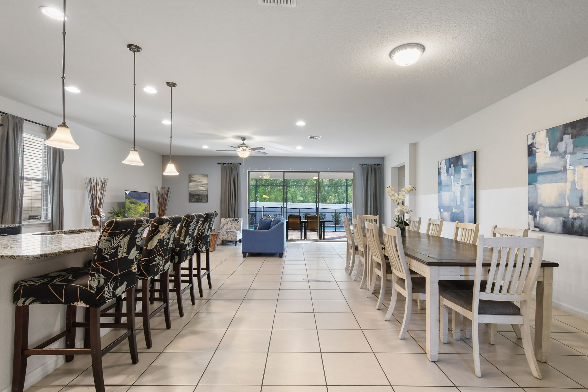 Spacious open layout with breakfast bar, dining for ten, and poolside views.