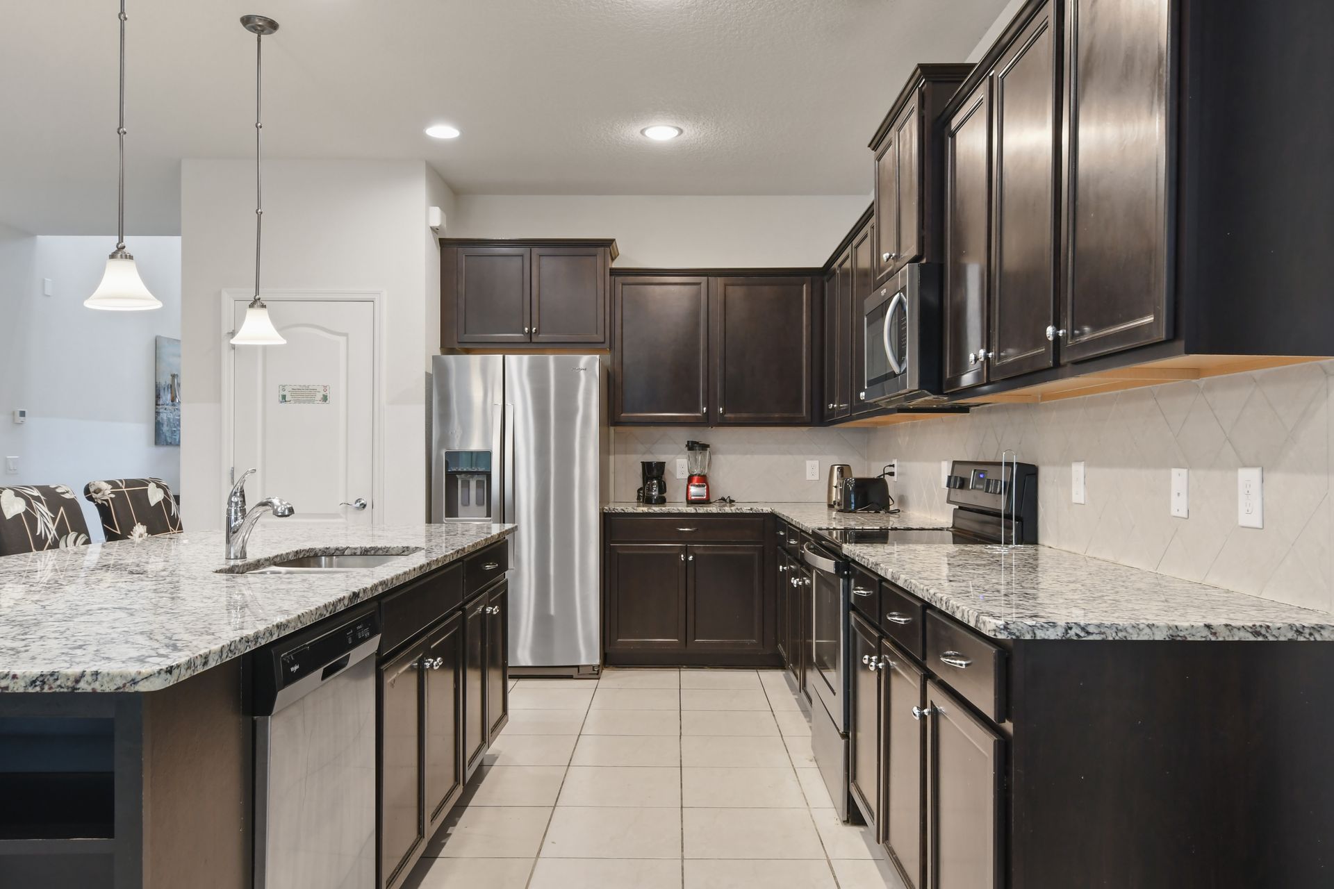 Gourmet kitchen with granite countertops, stainless steel appliances, and island.