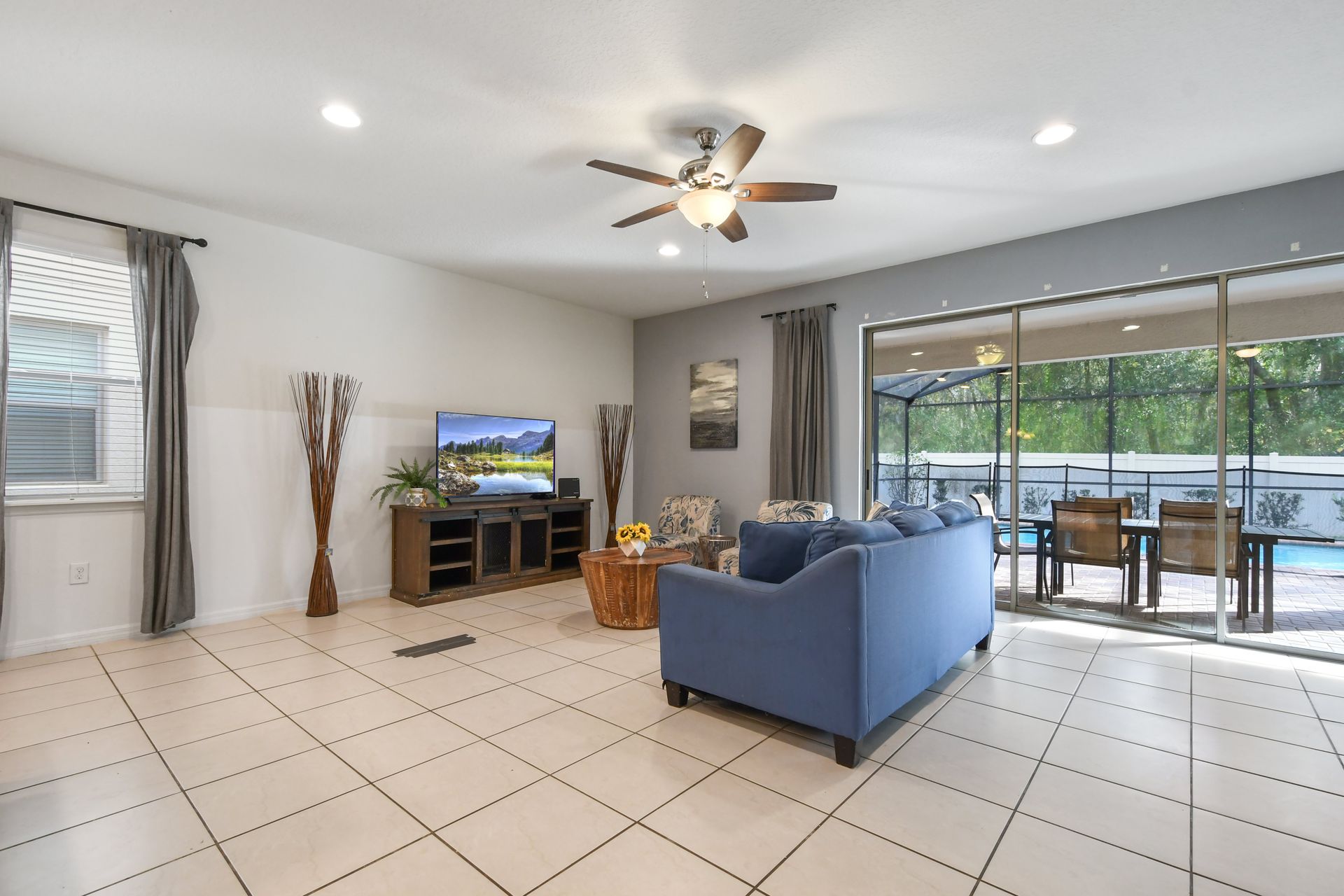 Relax in this bright living room with easy access to the poolside patio outdoors.