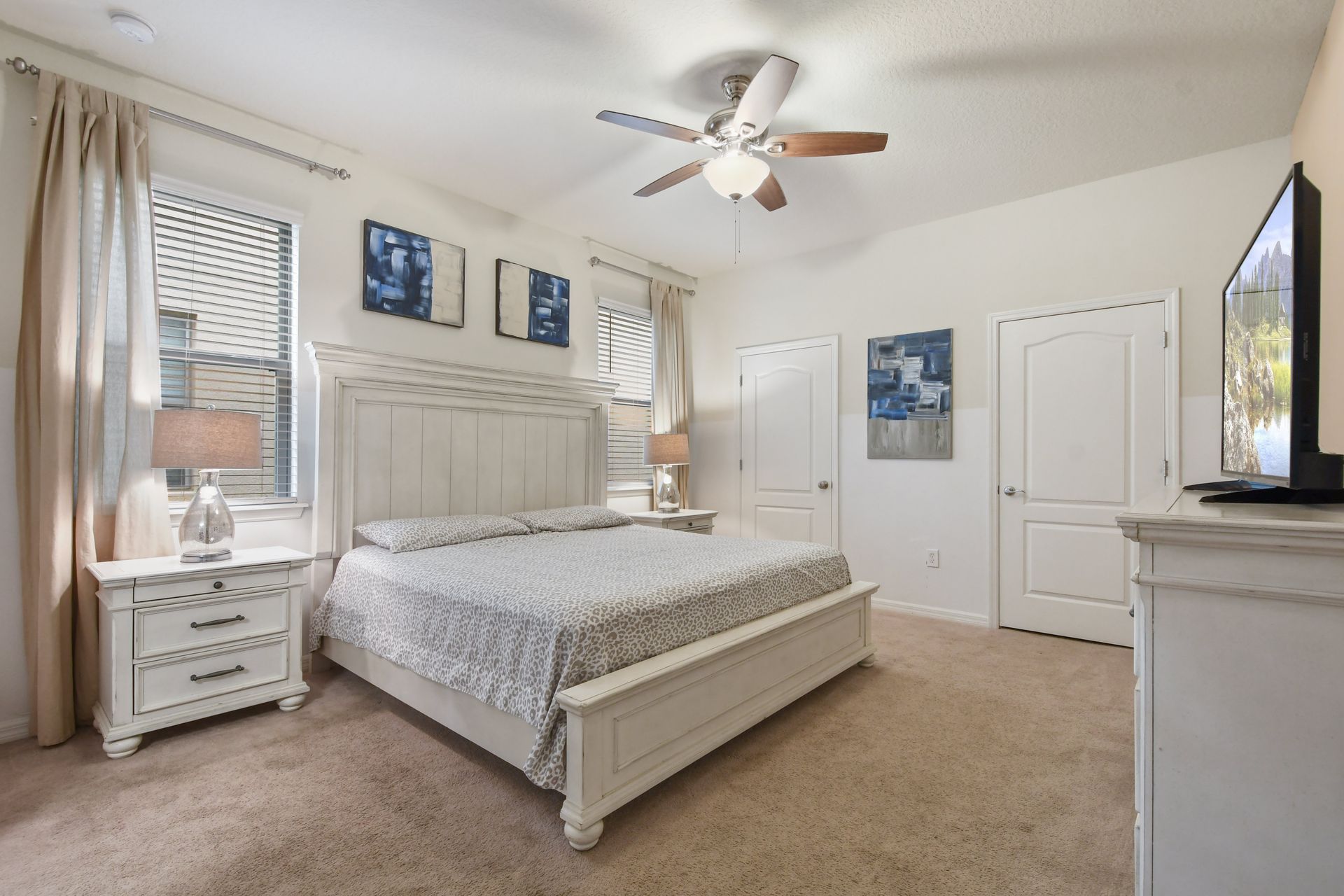 Spacious master bedroom with king bed, elegant decor, and natural light.