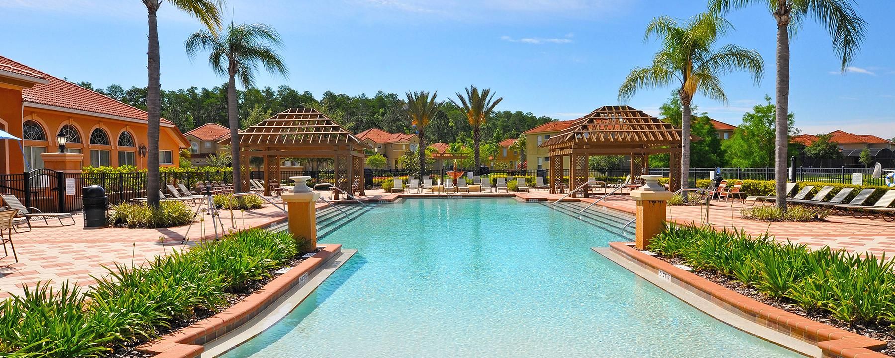 Resort-style pool with cabanas, palm trees, and sunny vibes