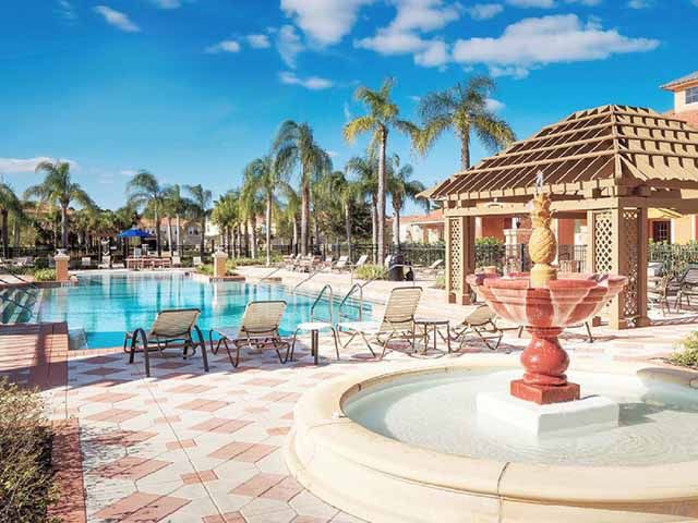 Resort-style pool with fountains, cabanas, and palm-lined views.