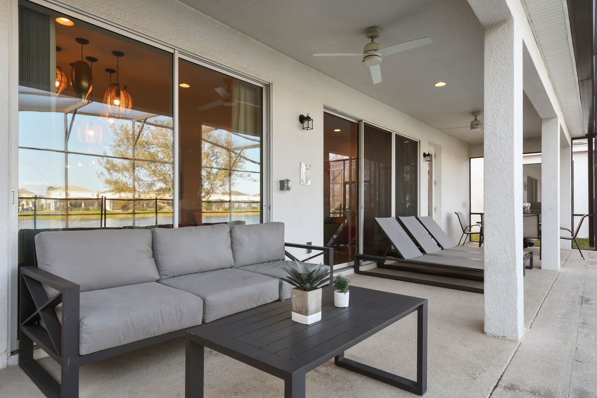 Relaxing outdoor area with sofa, coffee table, and loungers.