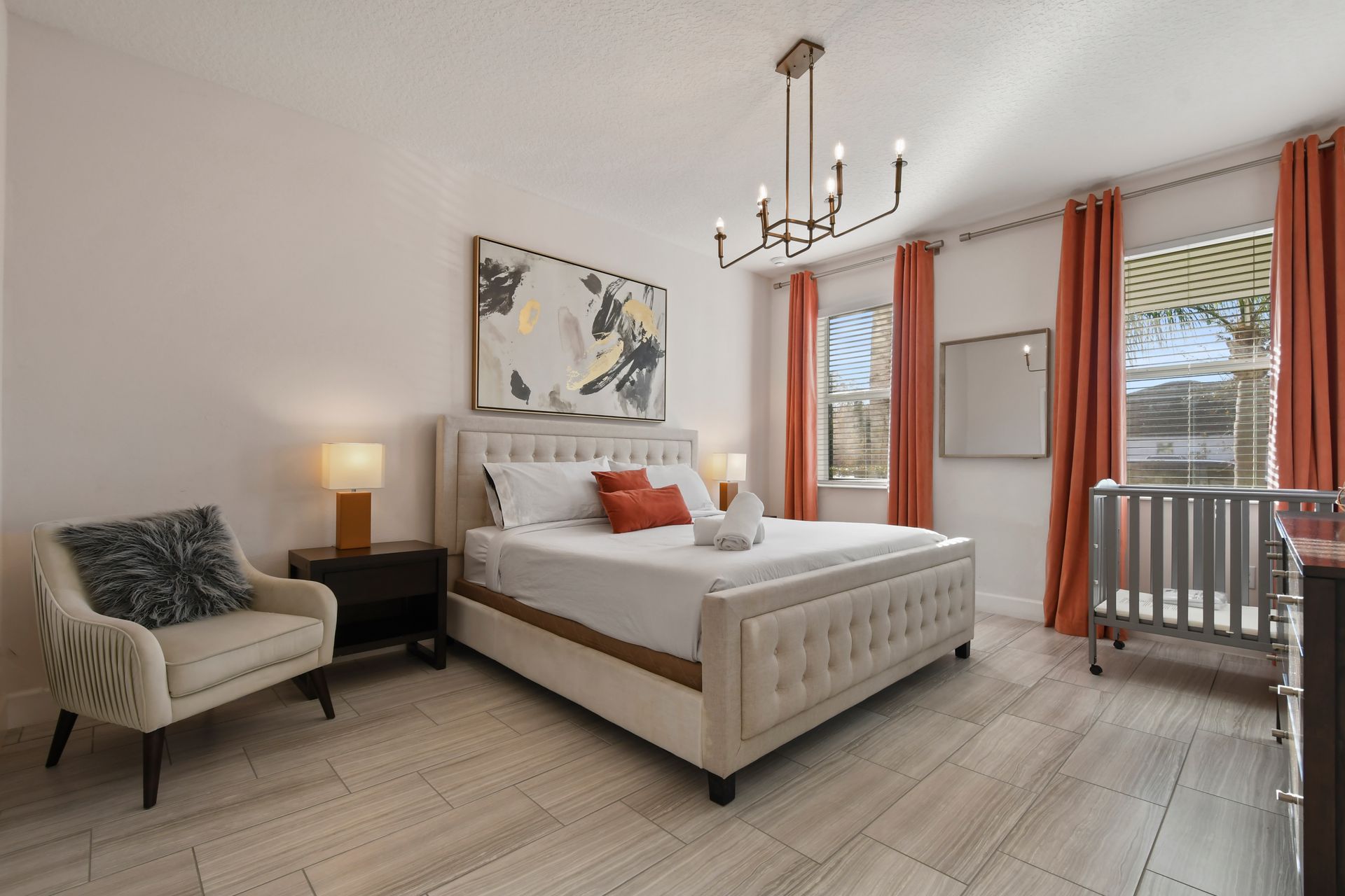 Elegant bedroom with a king bed, modern decor, and natural light