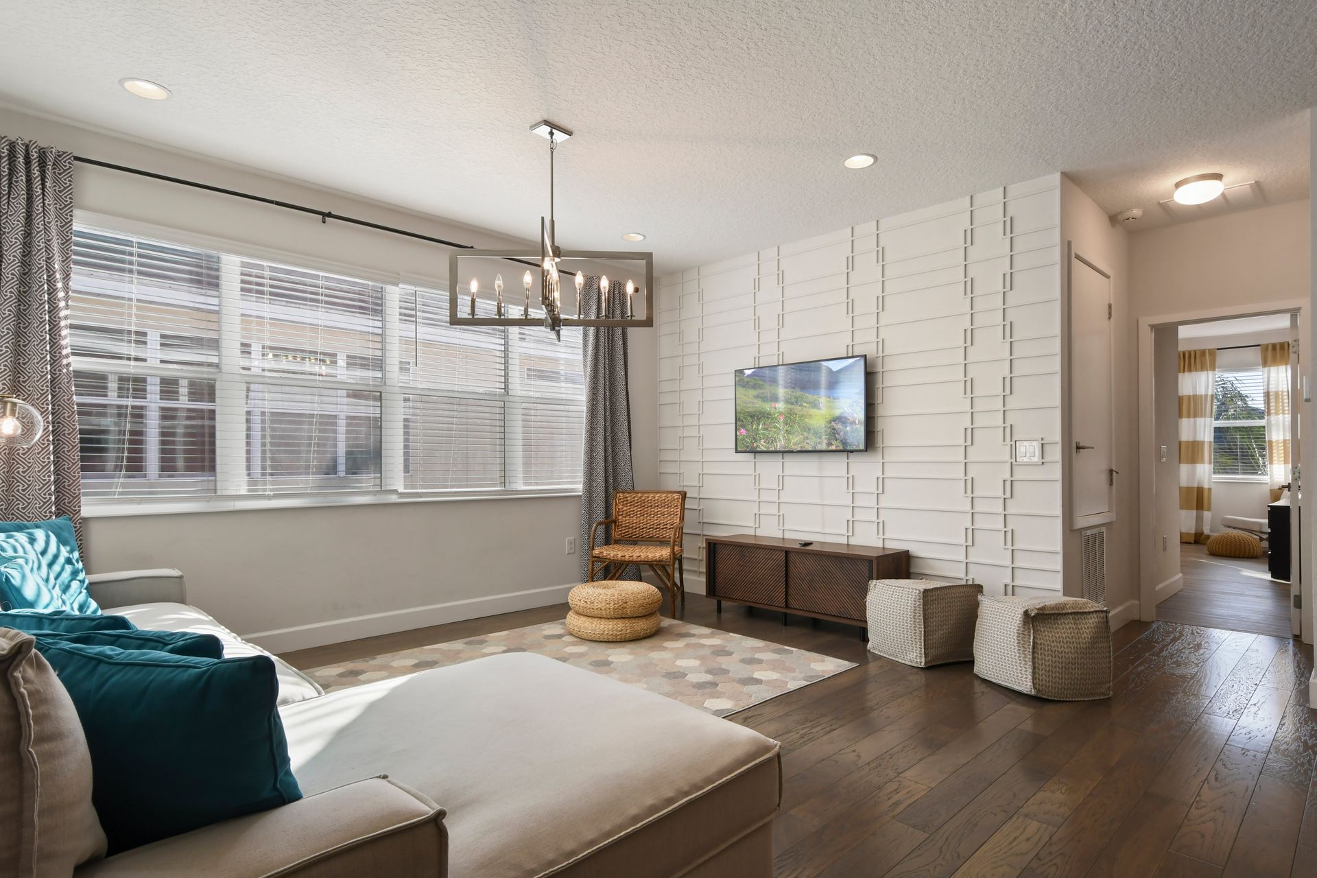 Sunlit lounge with modern accents, comfy seating, and smart TV