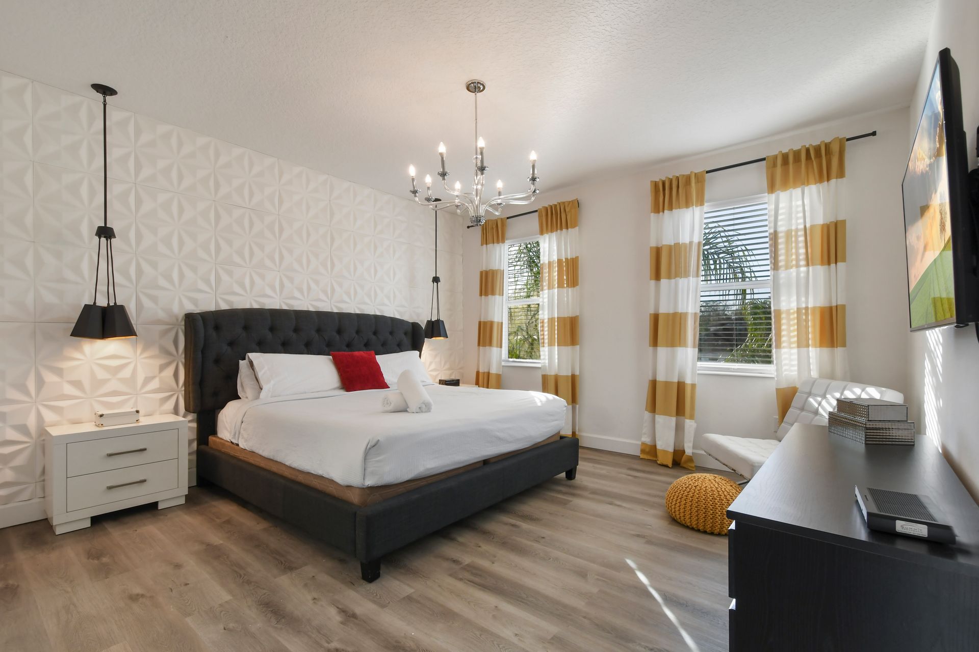 Spacious bedroom with bold accents, plush bedding, and natural light