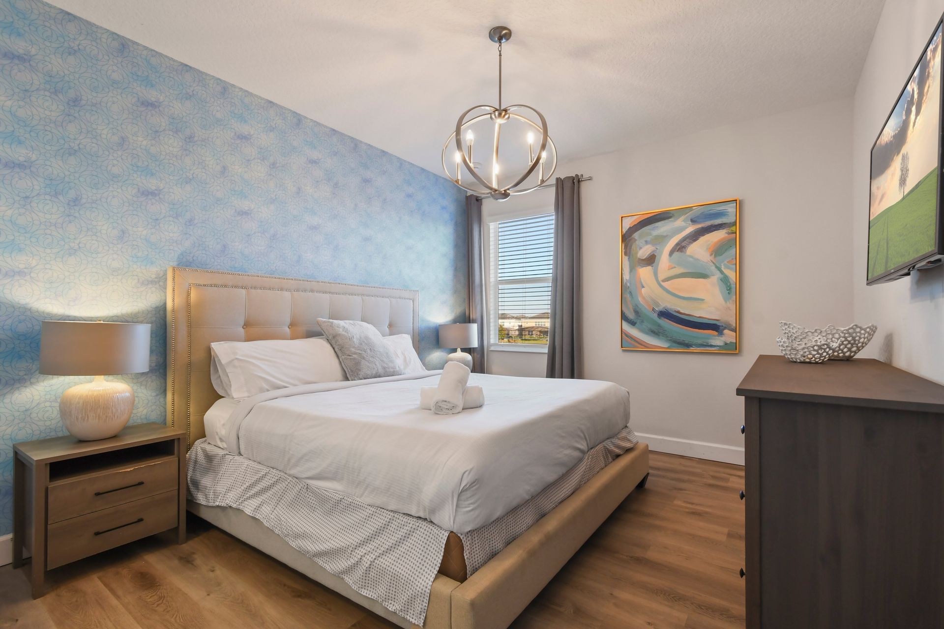 Elegant bedroom with calming blue accents, plush bedding, and stylish decor