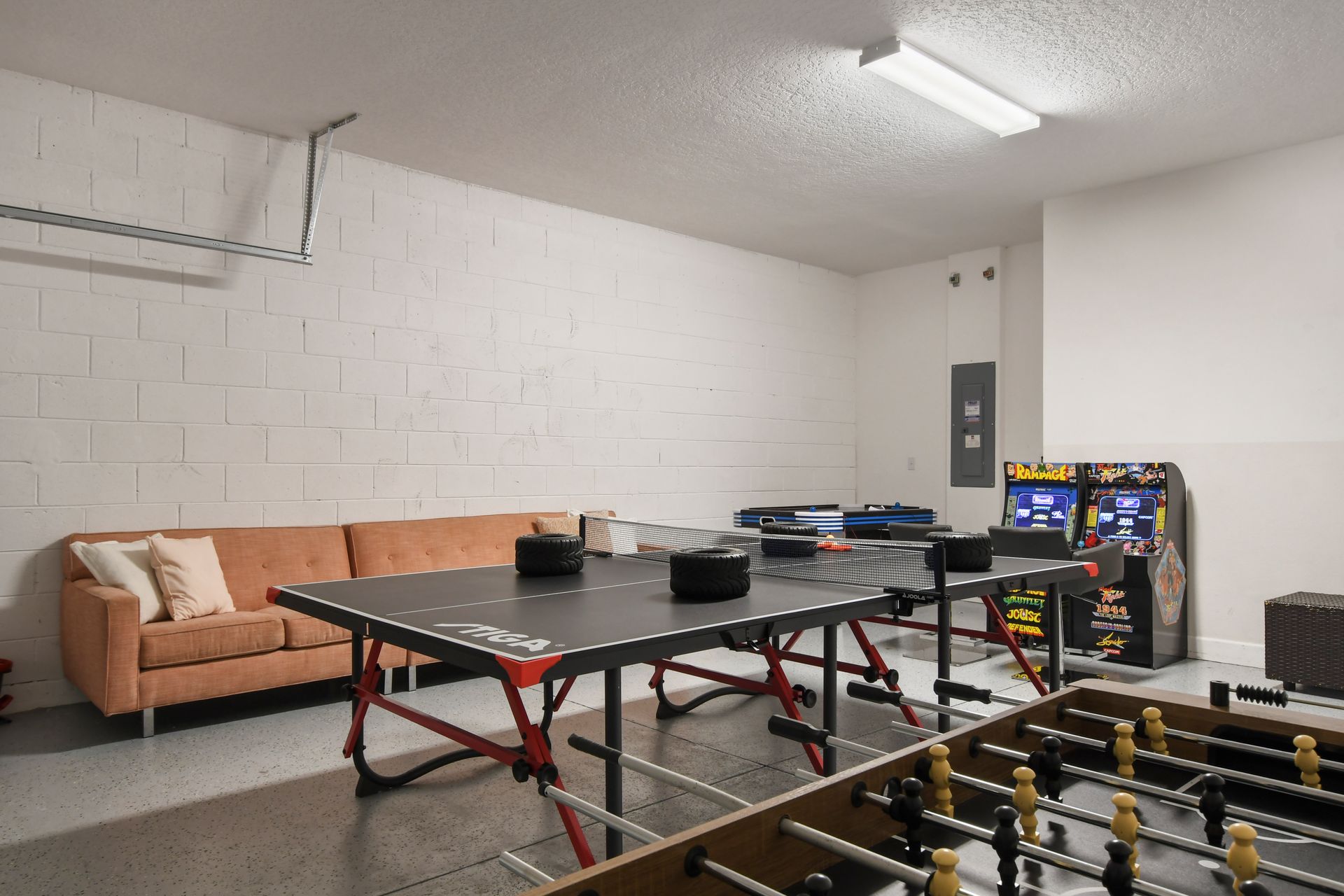 Ultimate game room with ping pong, foosball, arcade games, and a cozy sofa