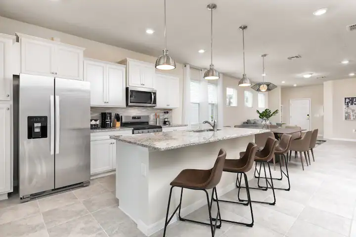 Modern kitchen with large island, stainless steel appliances, and ample seating.