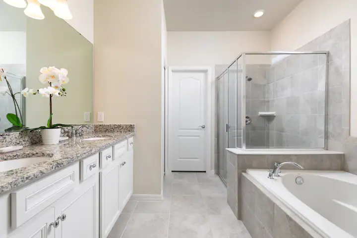Elegant bathroom with double vanity, soaking tub, and spacious glass-enclosed shower.