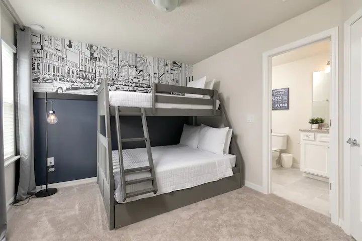 Stylish bunk room with cityscape mural and ensuite bath, perfect for families.