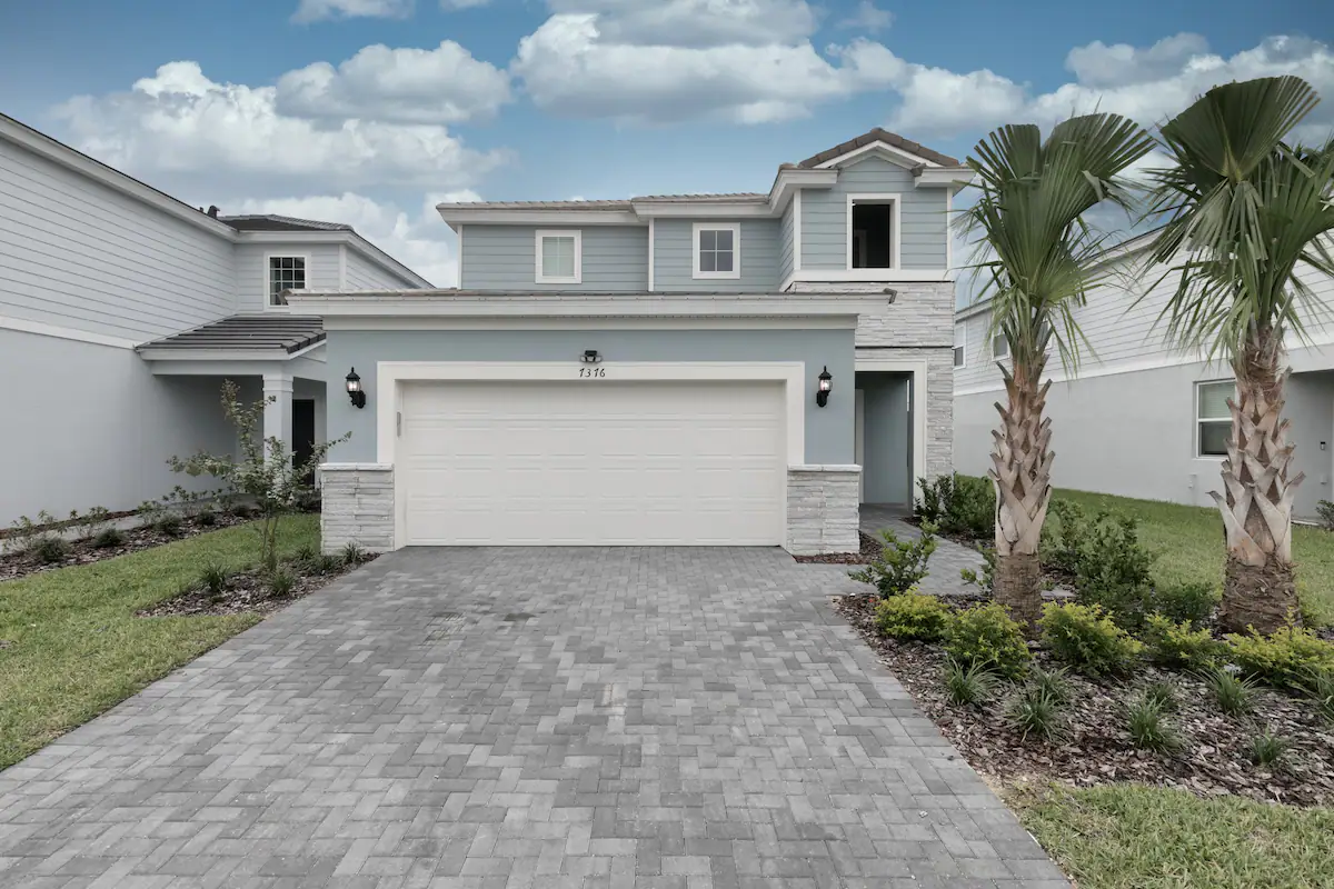 Stylish coastal home with modern charm, private driveway, and palm-lined entry.